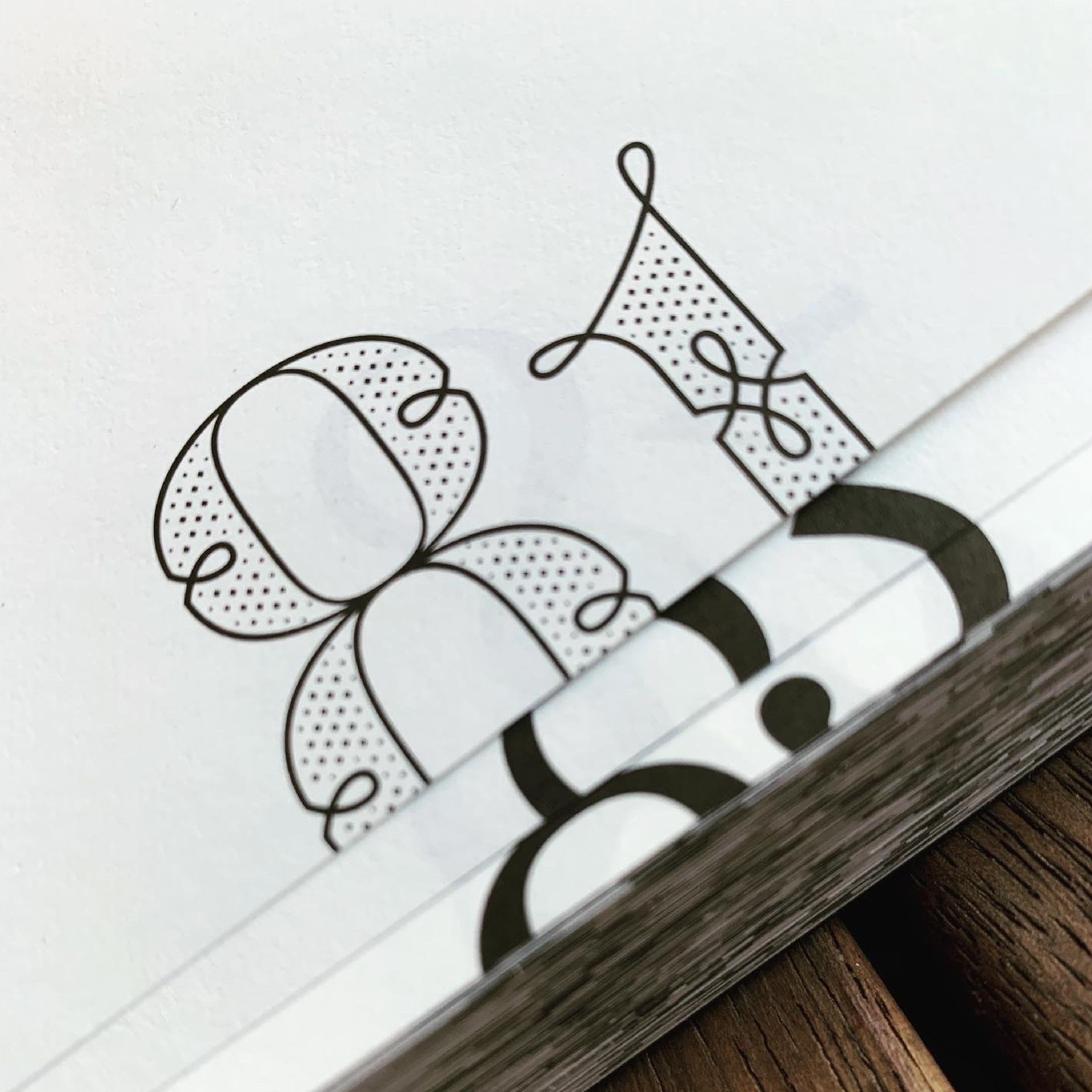 Green Fairy Font. Notebook page with black-and-white doodles and a pen resting along the edge