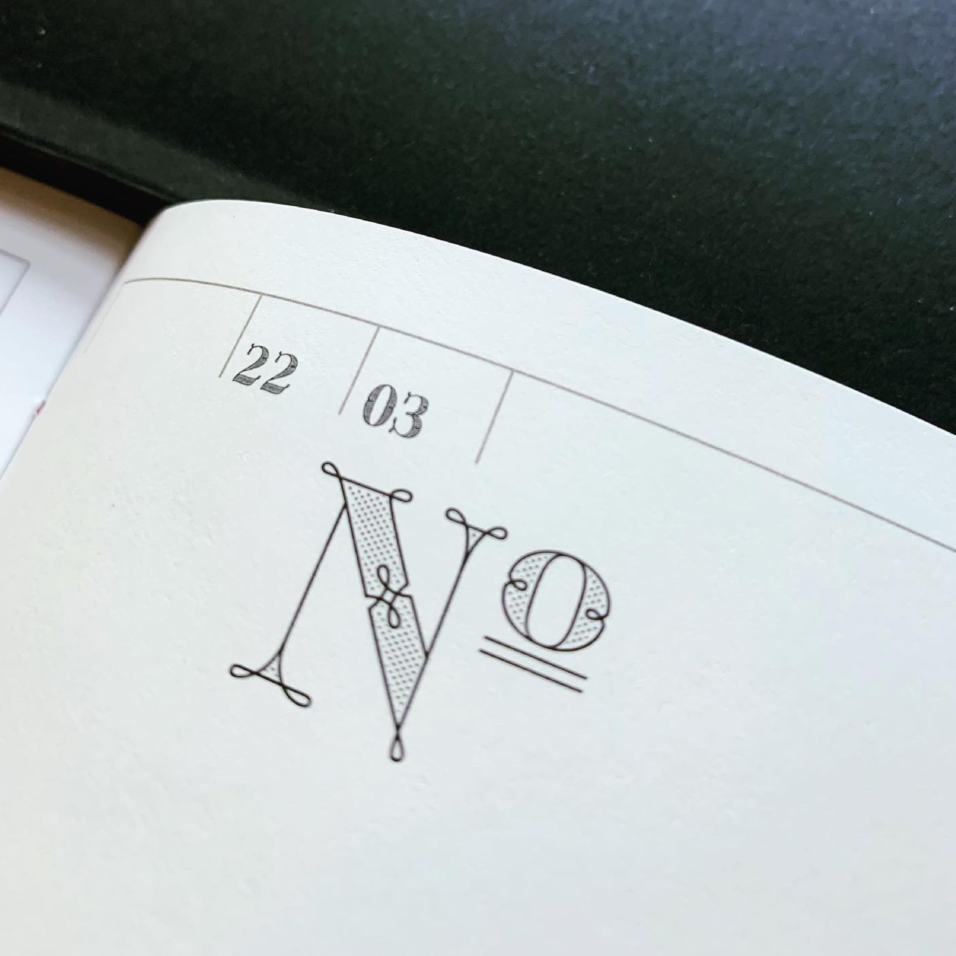 Green Fairy Font. Close-up of a sketchbook page with stylized letters, including “N” and “O,” and small date-like numbers at top left.