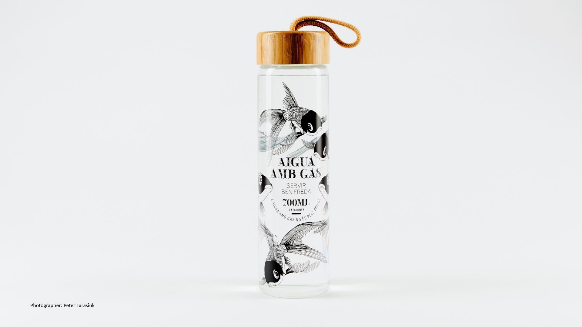 Green Fairy Font. White cylindrical bottle with black floral design and wooden cap on a white background