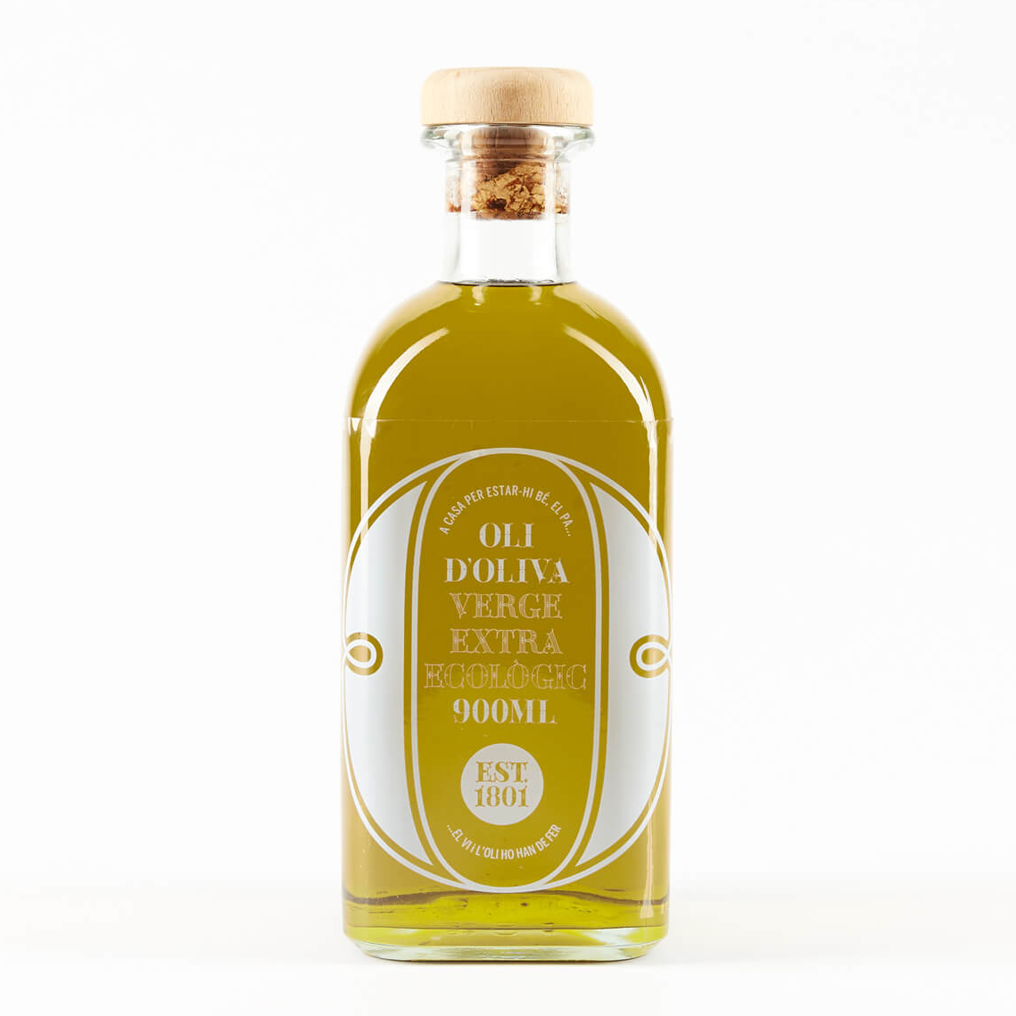 A clear glass bottle filled with golden olive oil, featuring a white oval label with text, topped with a cork stopper.