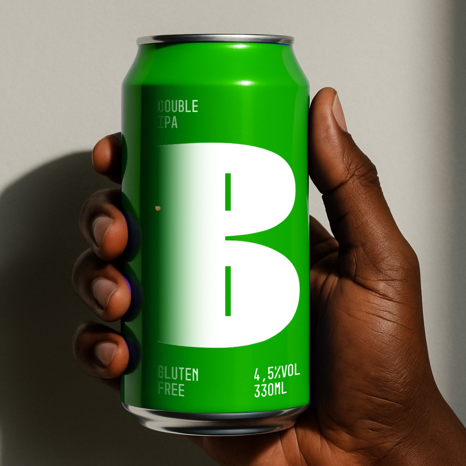 A hand holding a green soda can with a large white “B” on the label.