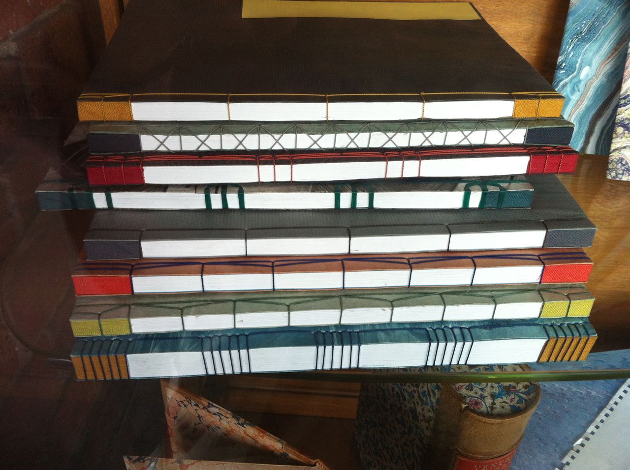 Stack of colorful woven mats or folders on a shelf in a room