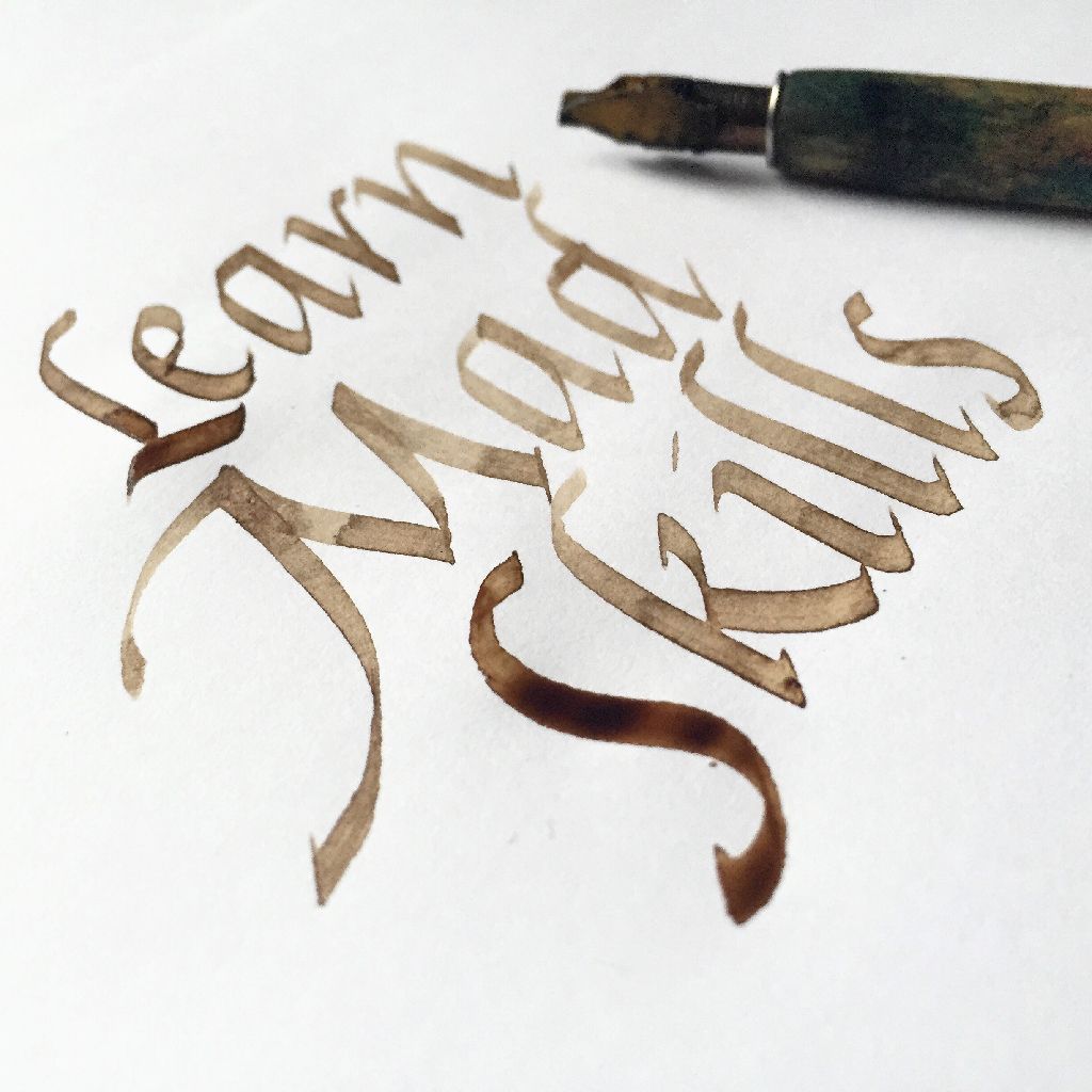 Calligraphy in brown ink on white paper reads 