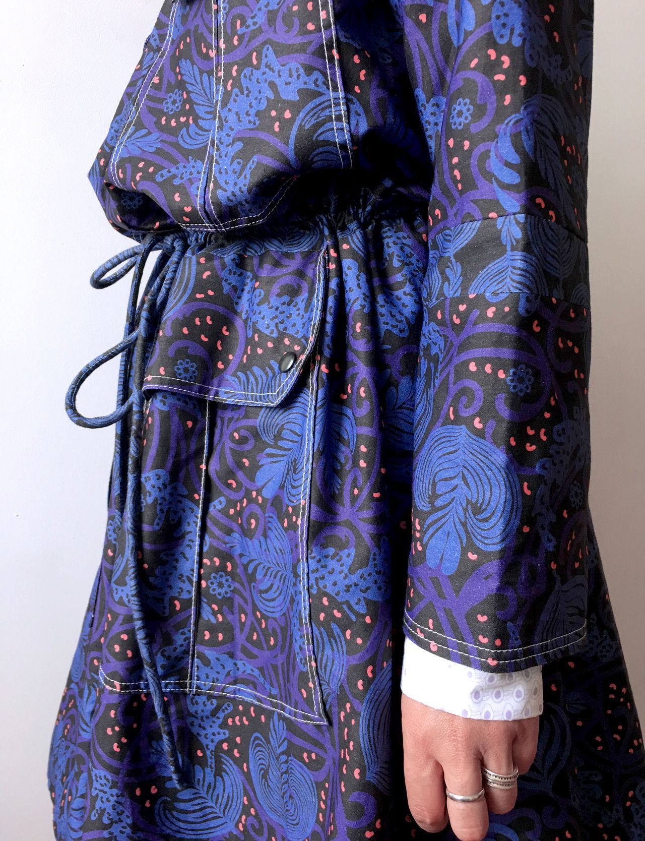 Blue patterned dress with black waist tie and white cuff, shown from the side