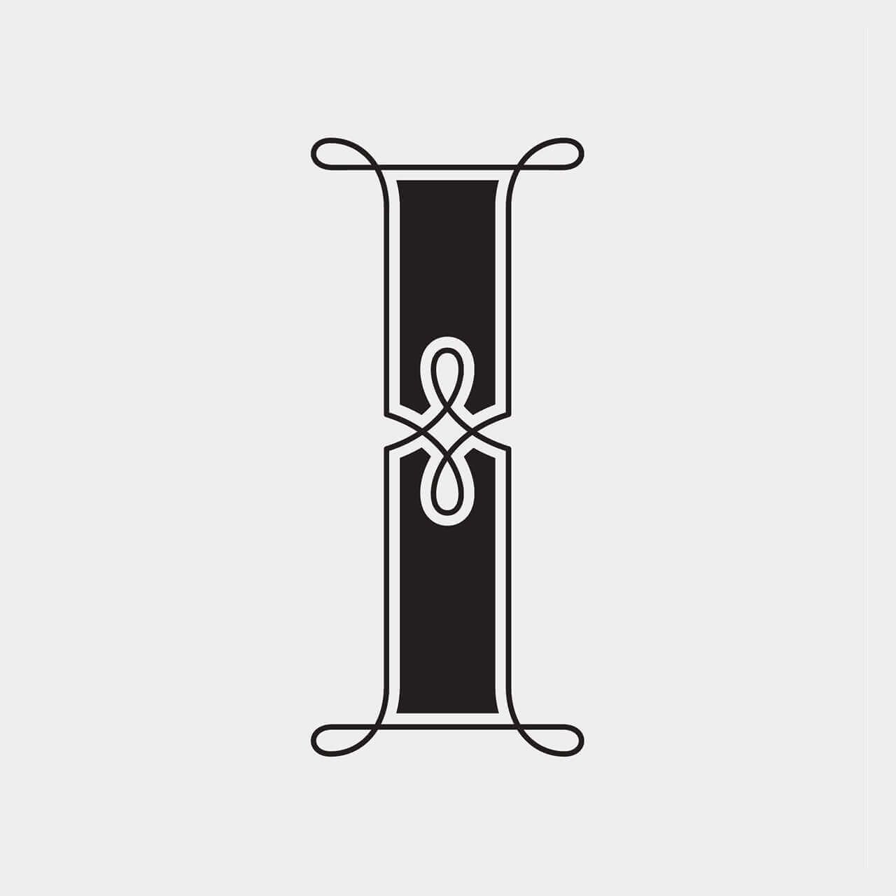 Green Fairy Font. Stylized black capital letter I with white outline and decorative curled serifs