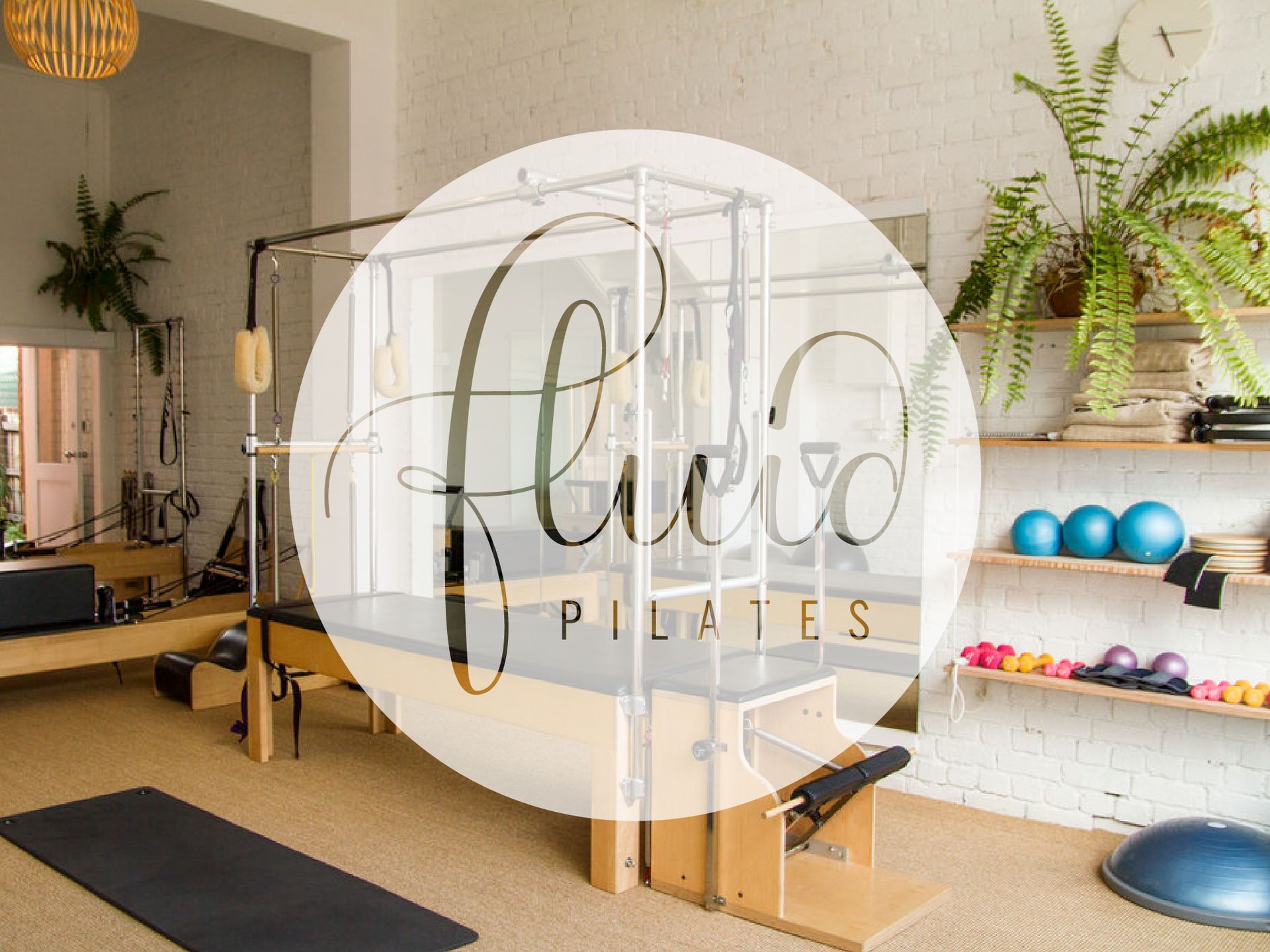 Pilates studio with reformer, mats, mirror wall, and colorful exercise balls