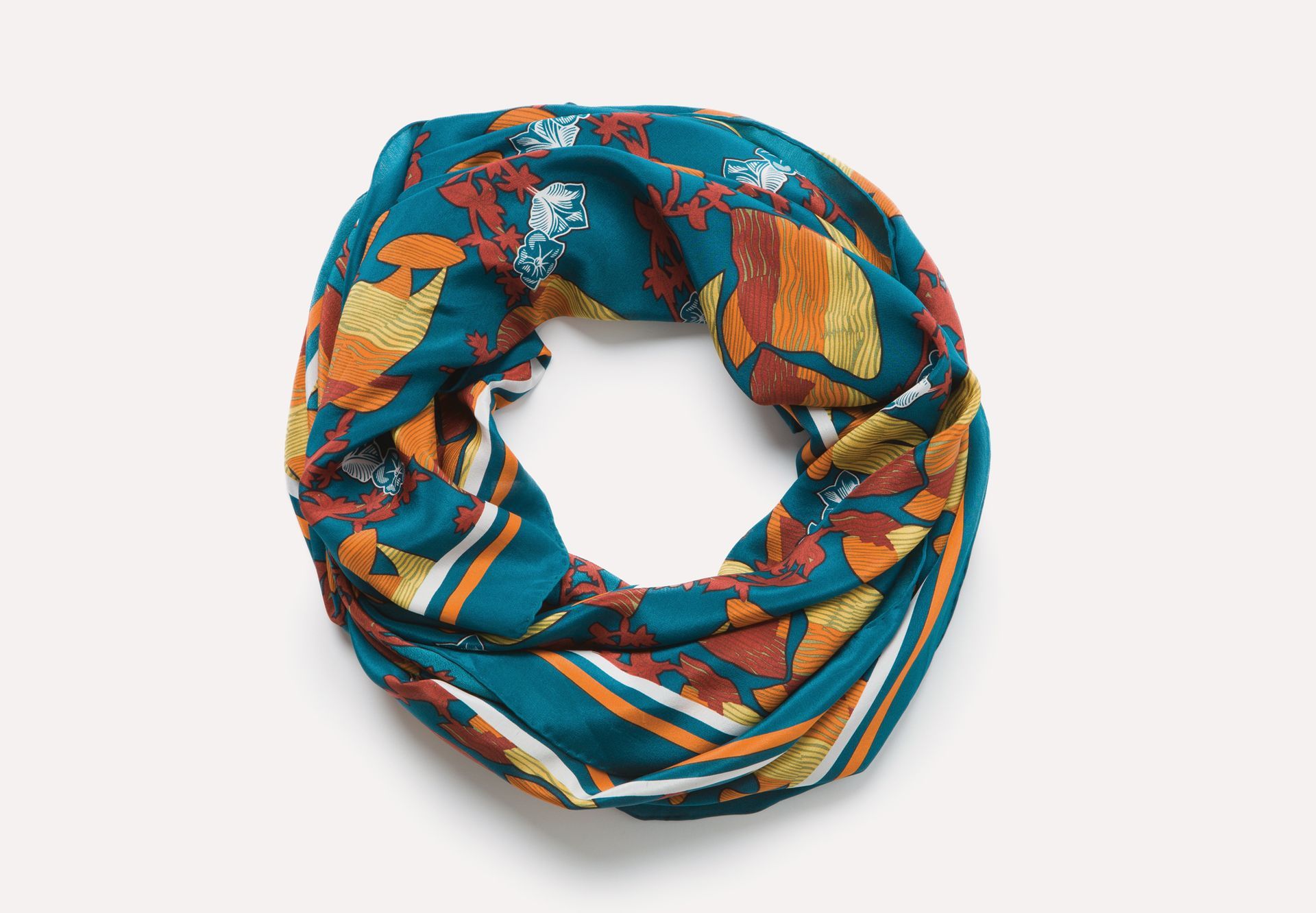 Colorful patterned infinity scarf in teal, orange, and white, coiled on a white background