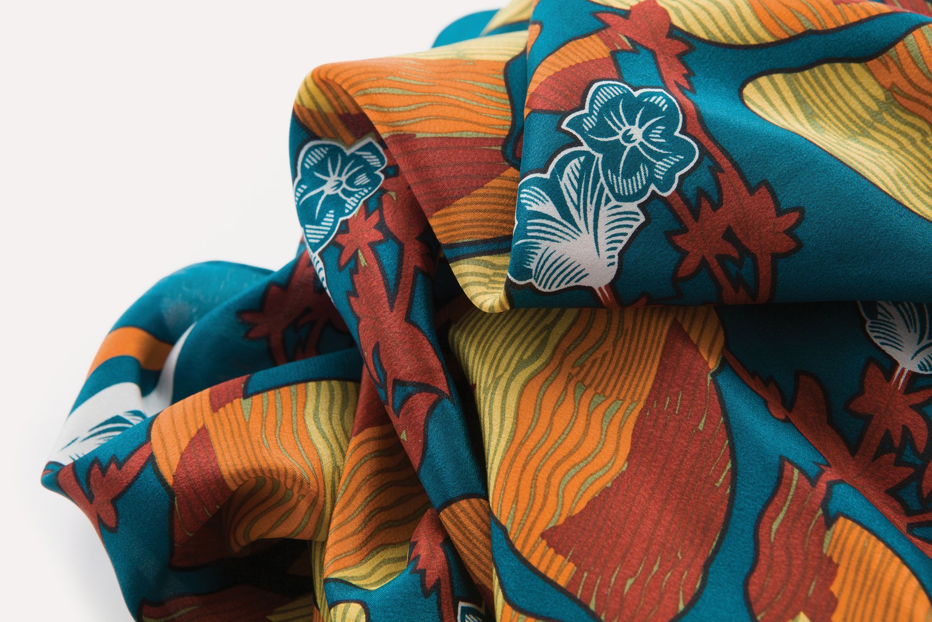 Stacked colorful patterned fabrics with orange, teal, and red floral designs