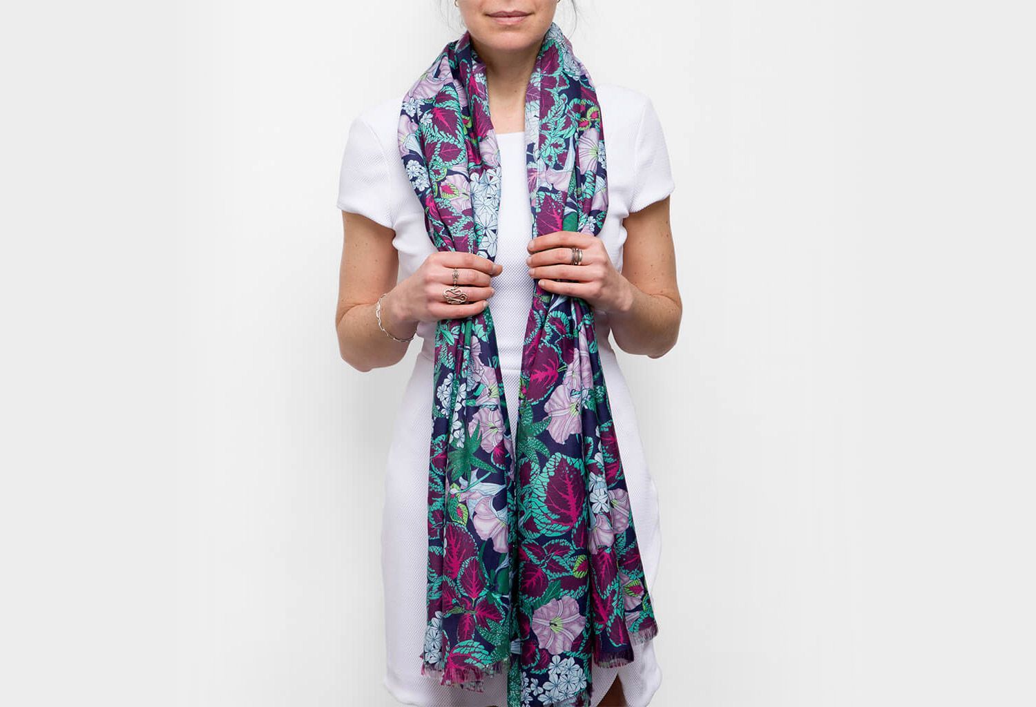 Maria Montes holding a colorful floral scarf over a white shirt