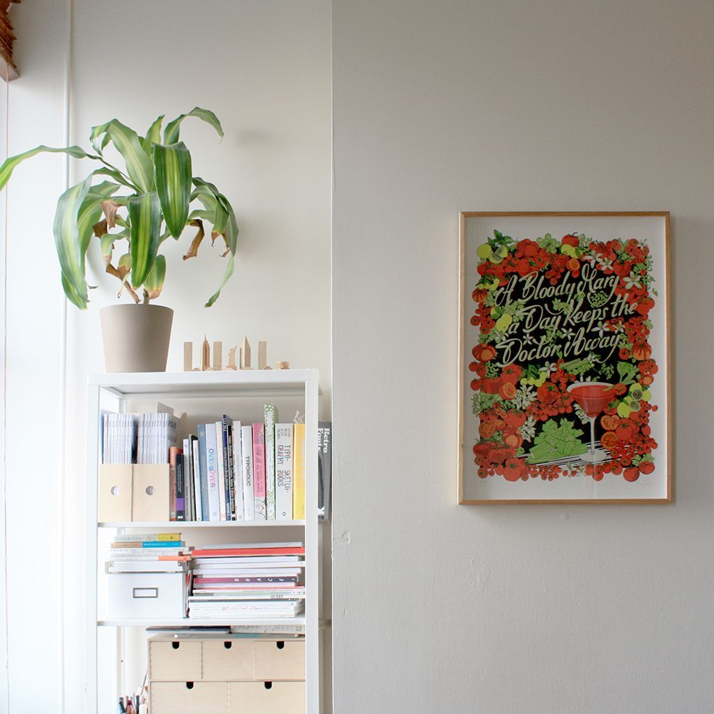 Minimalist room with a potted plant on a white shelf and a colorful framed poster on a gray wall