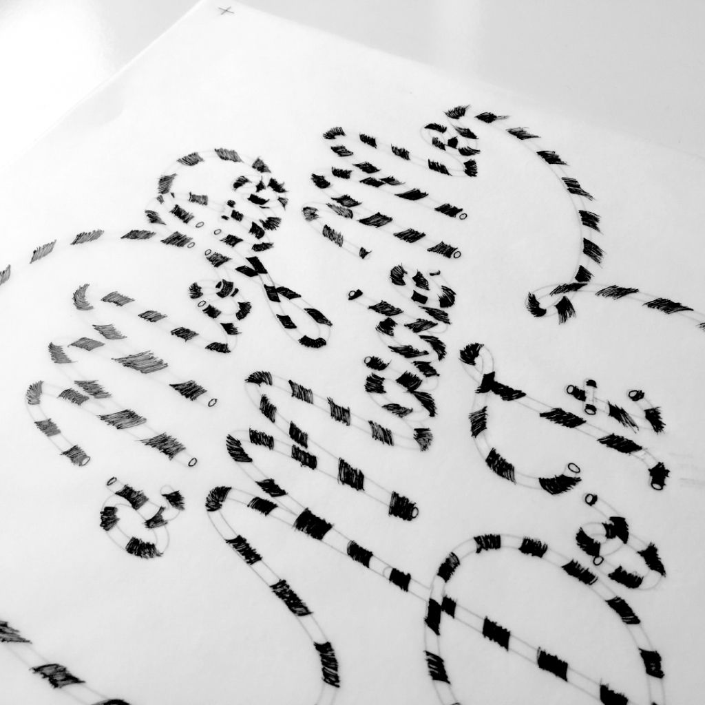Black-and-white aerial view of tire tracks forming a maze-like pattern in snow