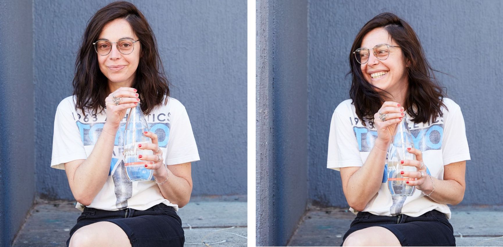 Maria Montes seated on a chair, smiling and holding a clear plastic cup with a straw against a blue wall.