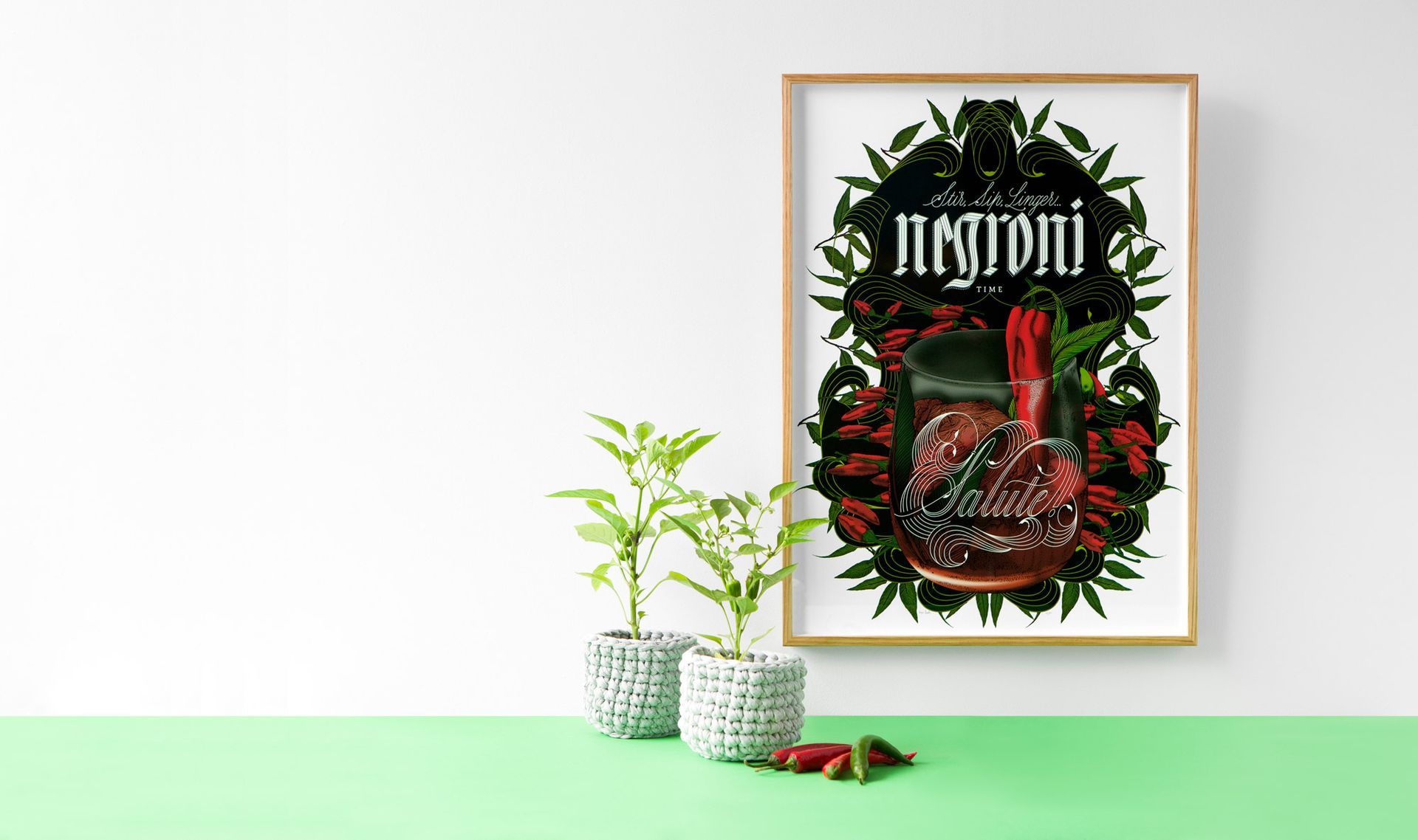 Framed botanical poster on a white wall with green plants on a mint shelf beneath it