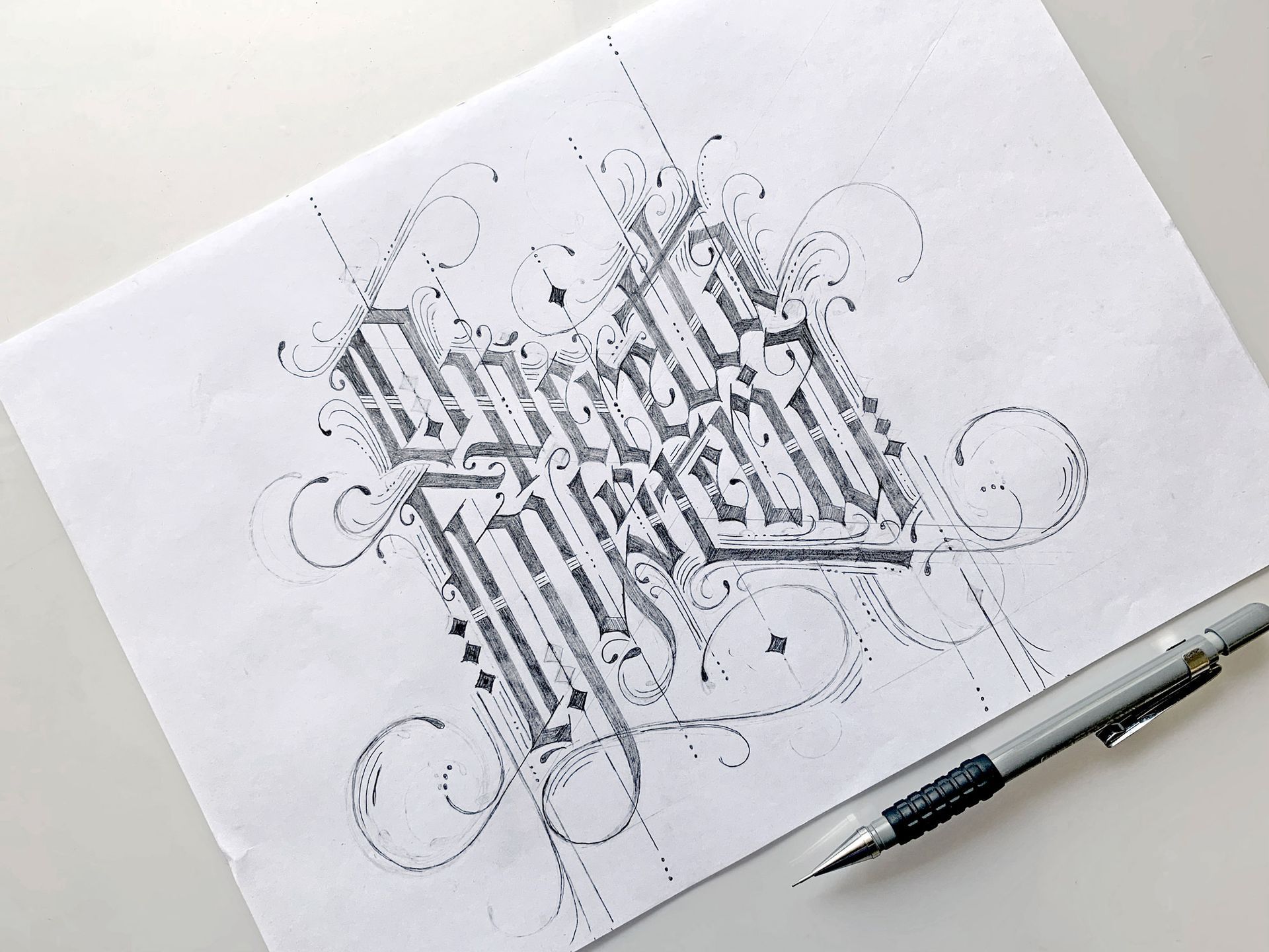 Black-and-white calligraphy sketch on white paper beside a pen
