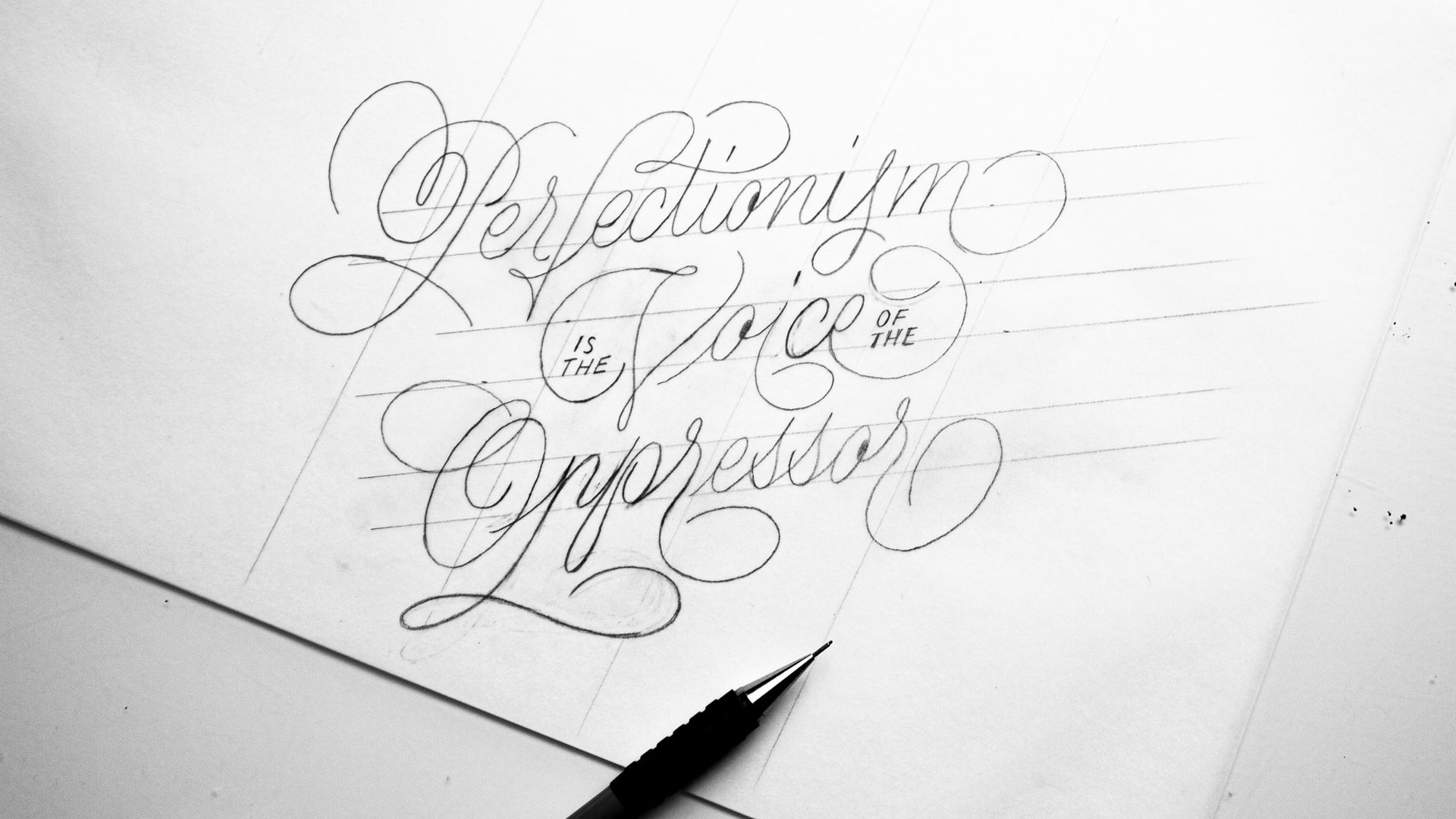Handwriting practice sheet with ornate cursive lettering and a pen tip at the bottom edge