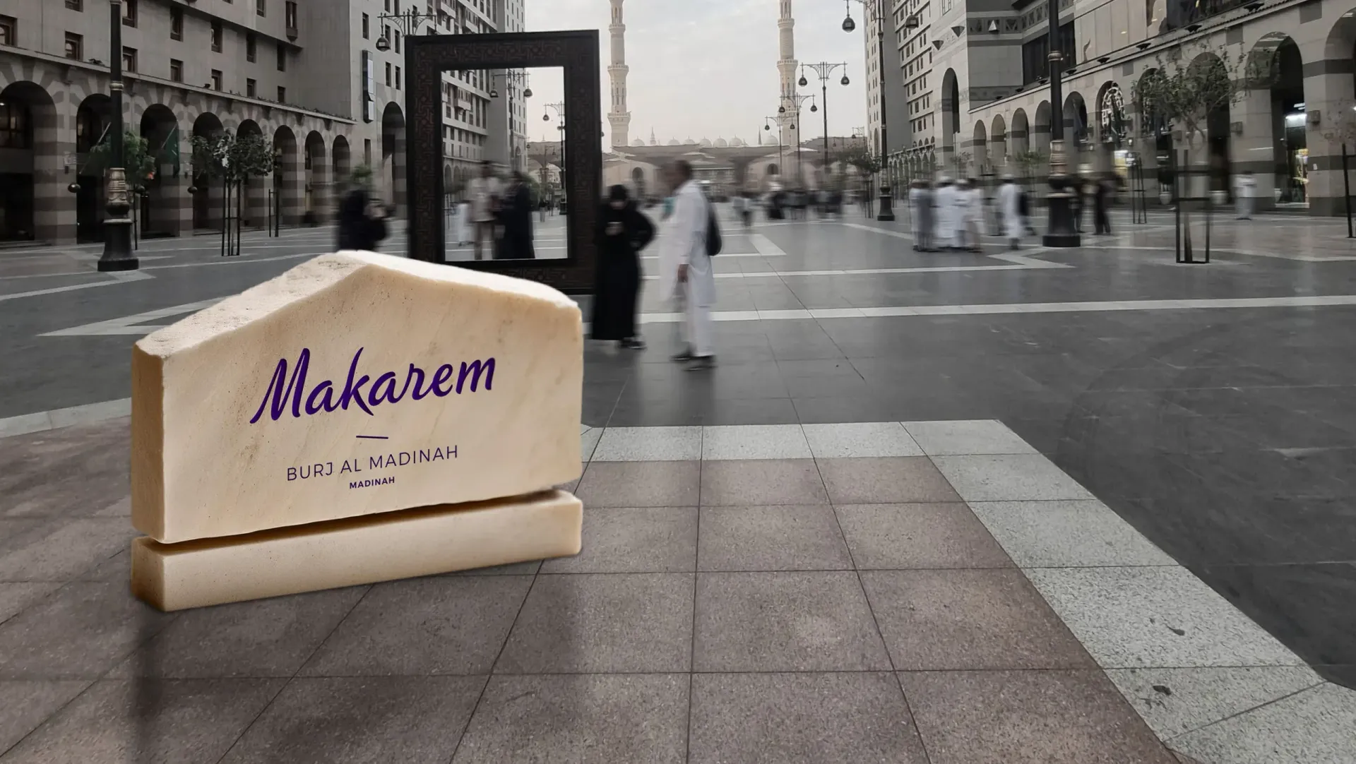 Makarem hotel sign on a city sidewalk with pedestrians and buildings in the background