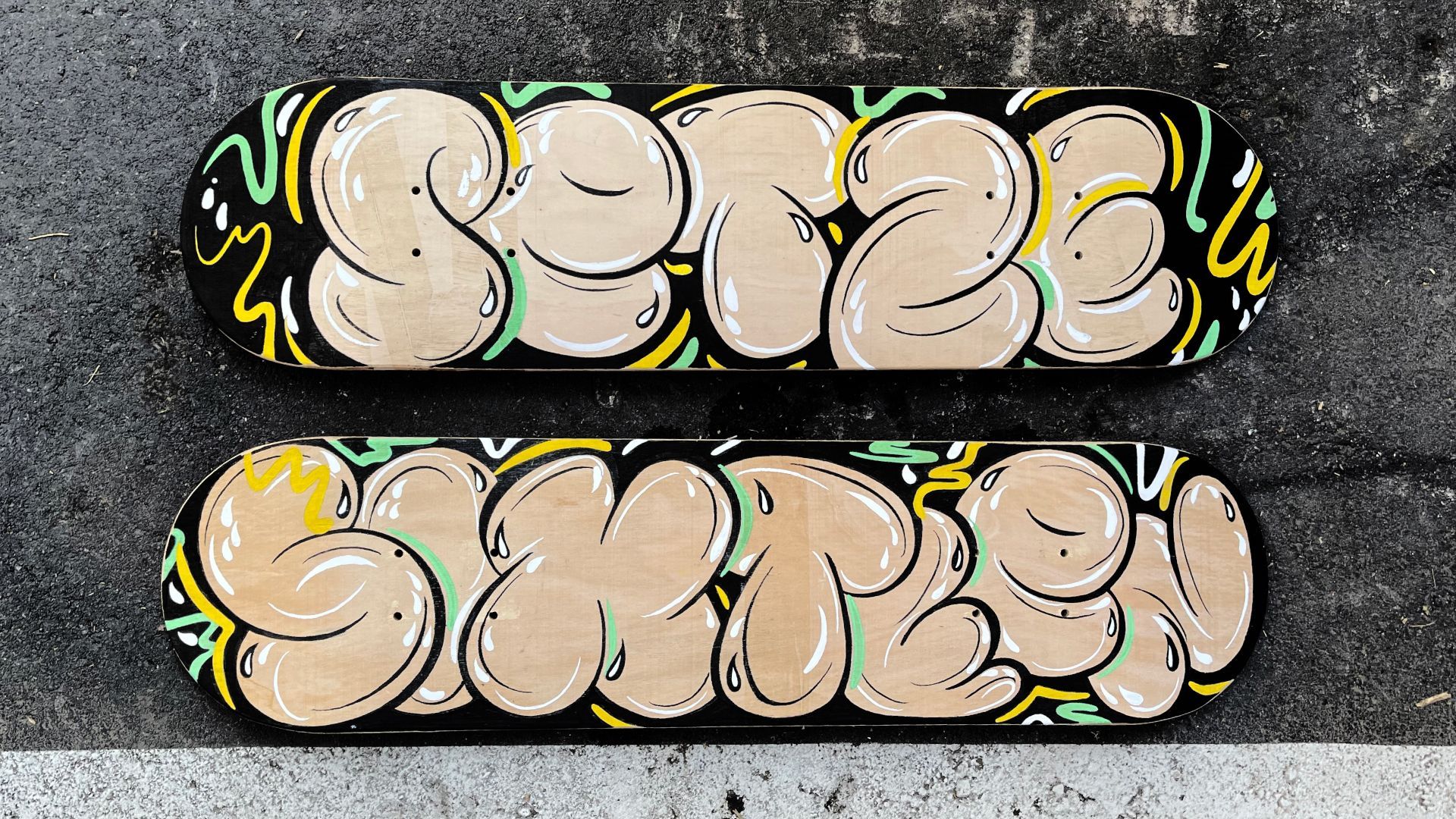 Graffiti-style bubble-letter mural in cream, green, and yellow on a gray brick wall