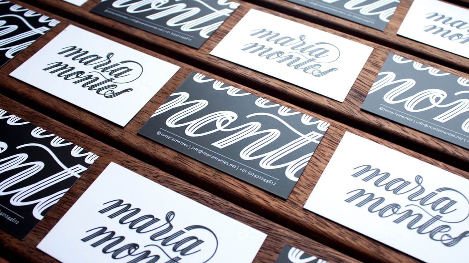 Black and white calligraphy cards reading “mama” and “mama mama” arranged on a wooden surface