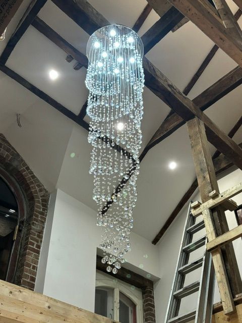 Lustre en cristal suspendu à un plafond à poutres apparentes.