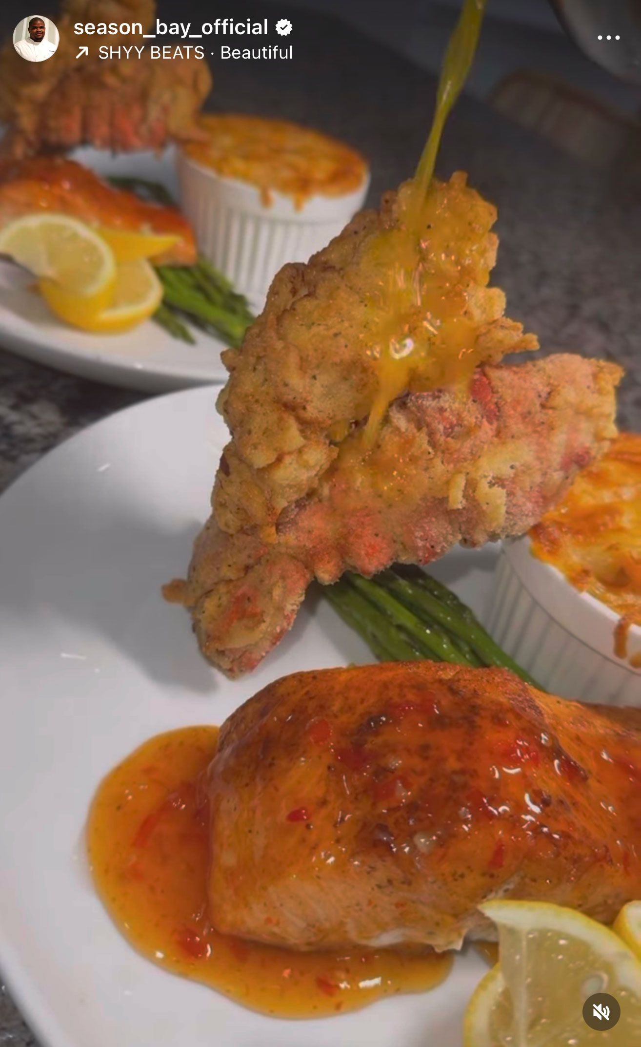 Fried salmon with sauce drizzled on, baked salmon, mac and cheese, and asparagus on plates.