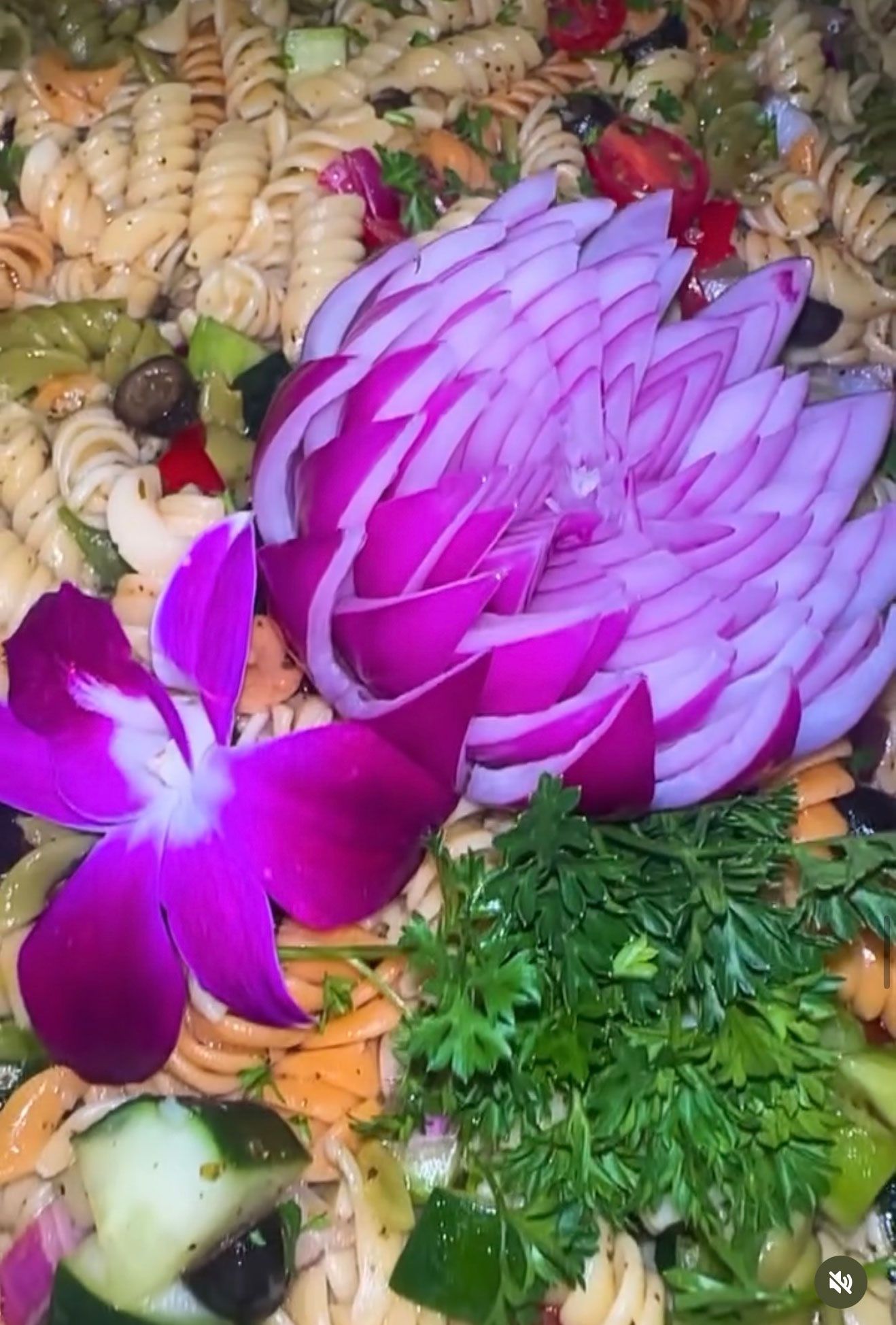 Pasta salad with purple onion flower and orchid.