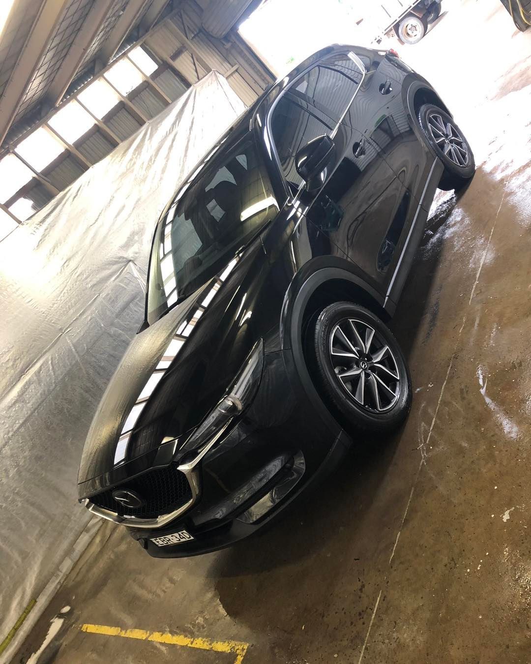 Black SUV Parked in A Wet Indoor Garage, Angled Side View — Diamond Glow Auto Detailing in Armidale, NSW
