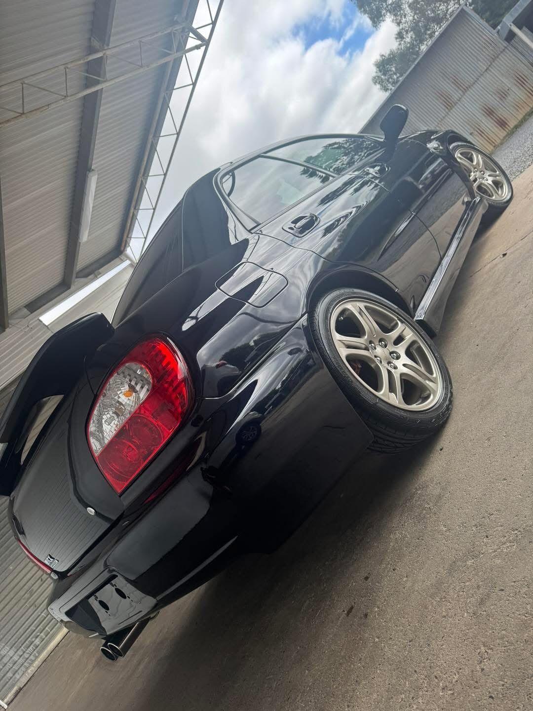 Black Sedan Parked at A Curb Beside a Building Under an Overpass — Diamond Glow Auto Detailing in Armidale, NSW