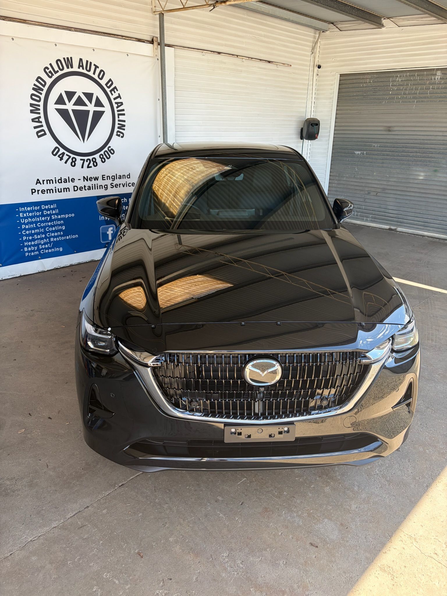 Gray SUV Parked Beside a White Building Under a Blue Sky with Clouds — Diamond Glow Auto Detailing in Armidale, NSW