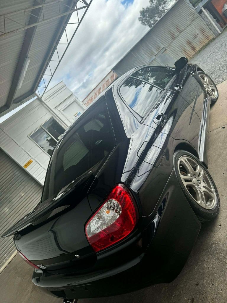 Black Sedan Parked Beside a Building Viewed from The Rear at An Angle — Diamond Glow Auto Detailing in Armidale, NSW