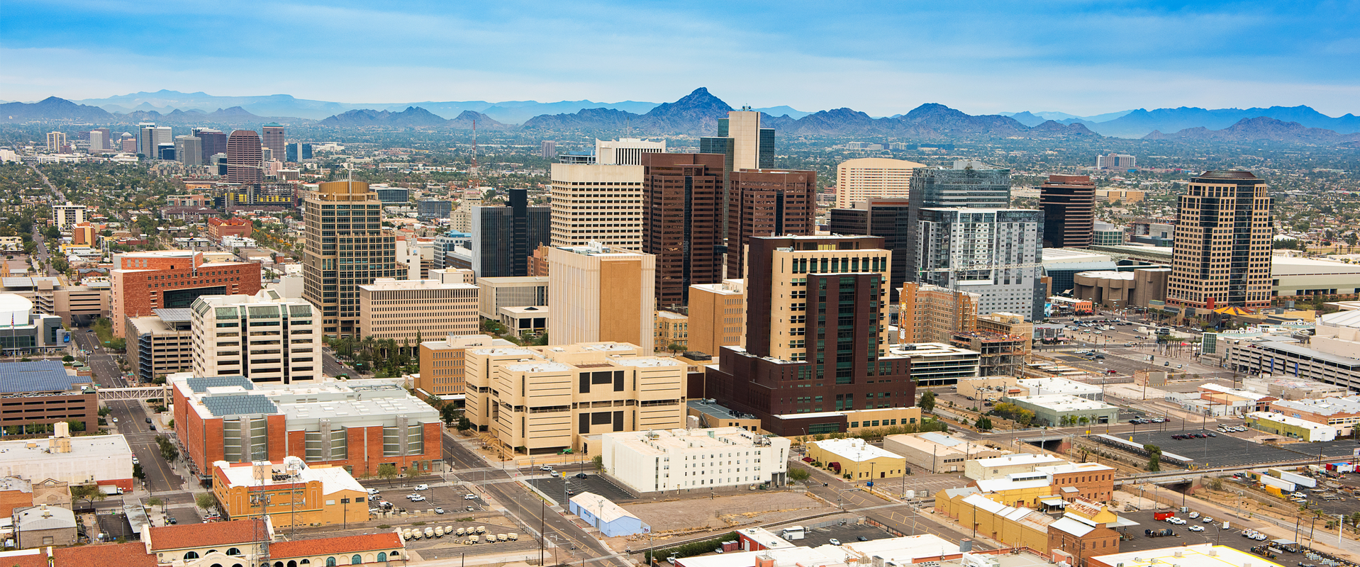A city skyline with tall buildings and trees in the foreground