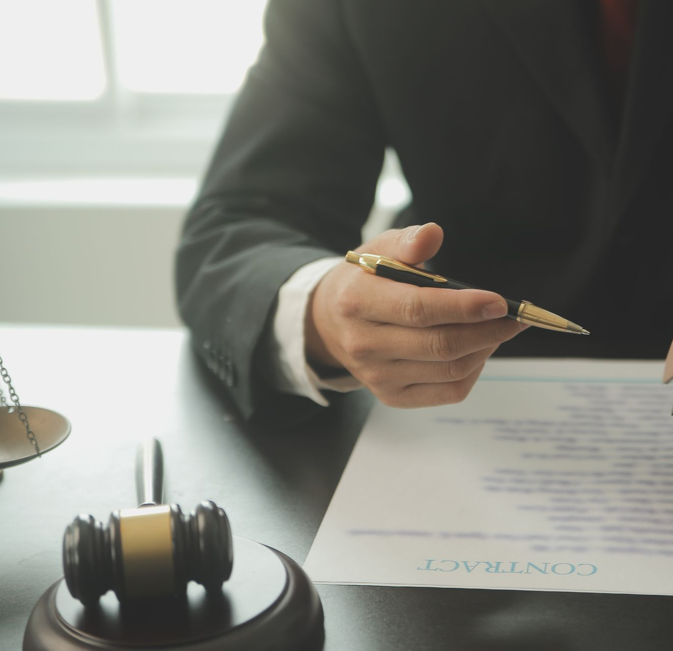Person in suit pointing a pen at a