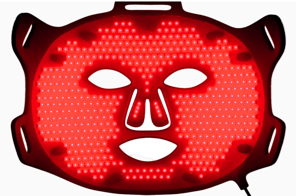 Red glowing devil mask with white eyes and mouth on a dark background