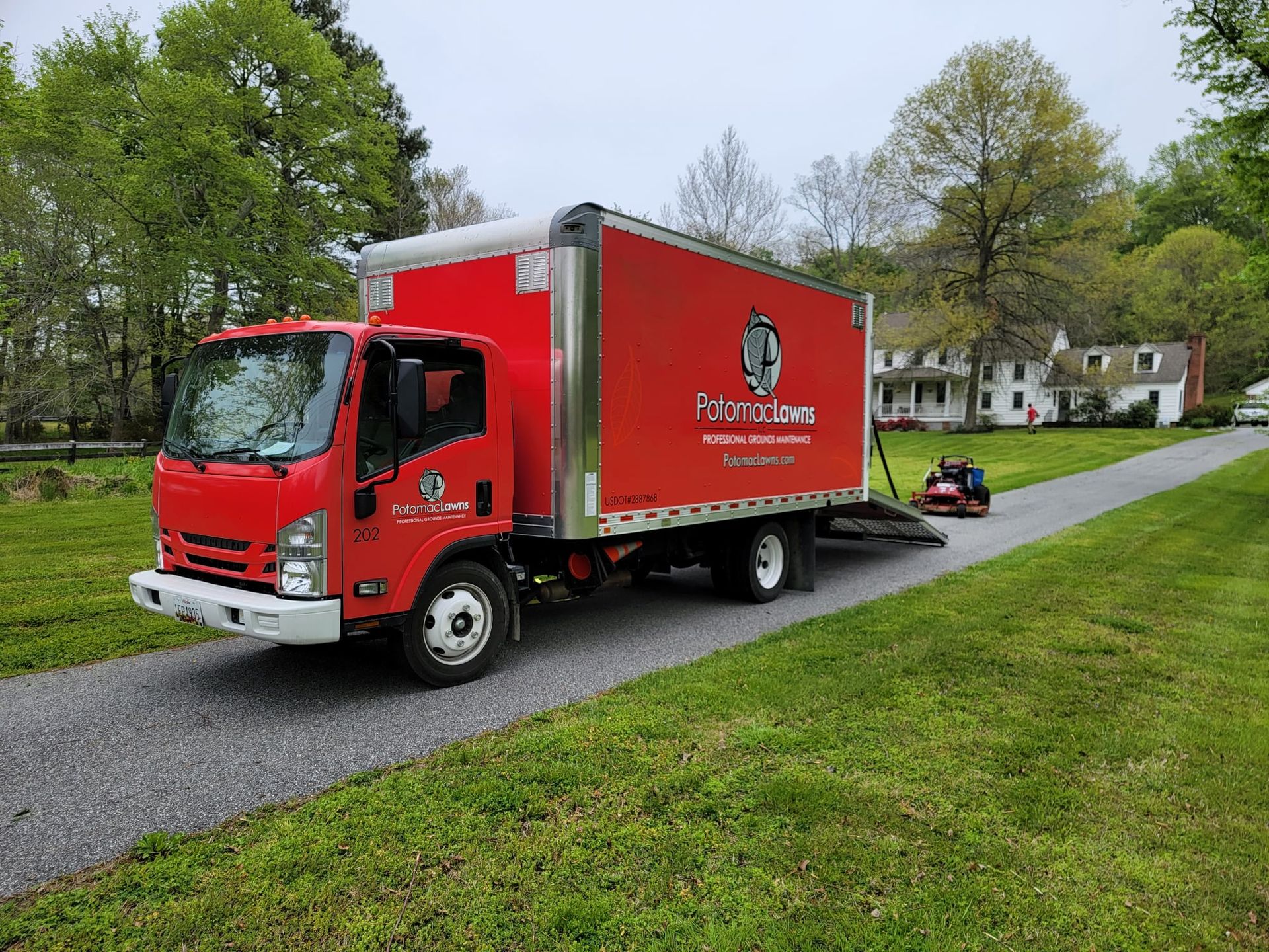 A red moving truck is parked on the side of a road.
