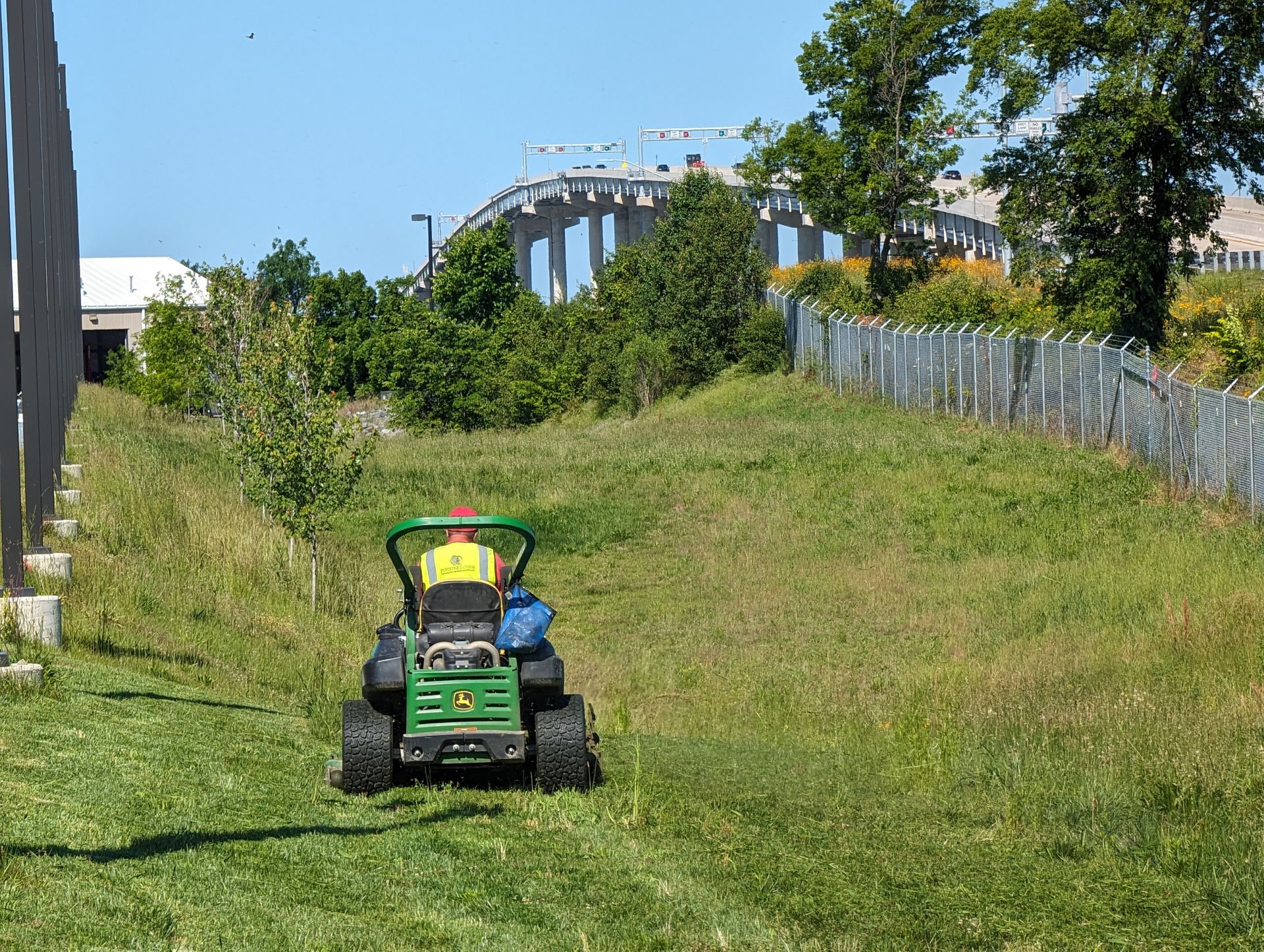 A man is riding a lawn mower in a grassy field.