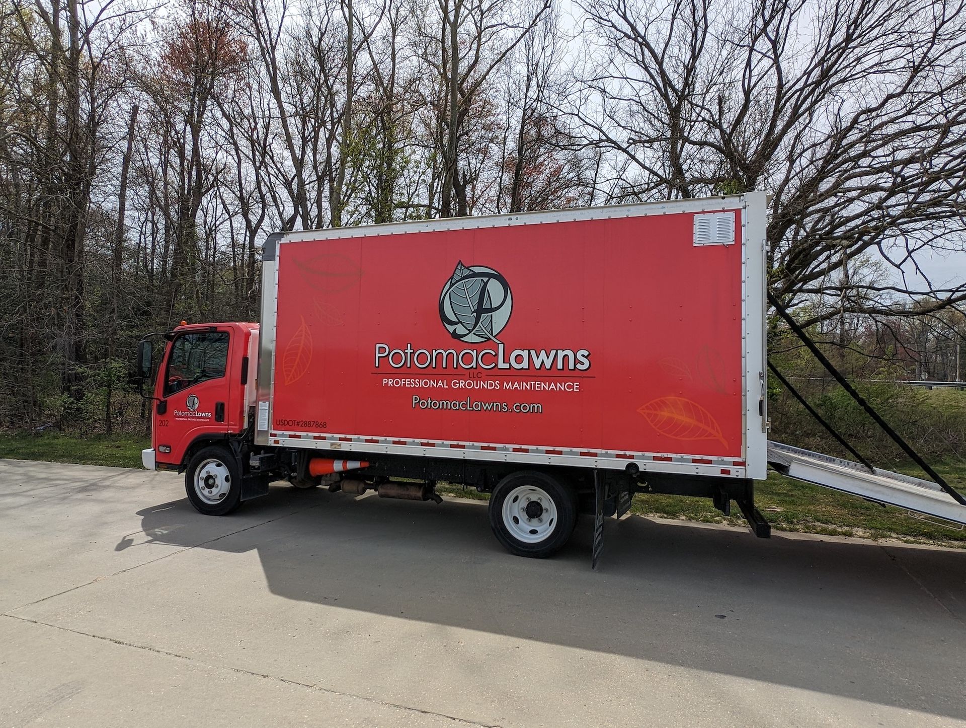 A red box truck is parked on the side of the road.