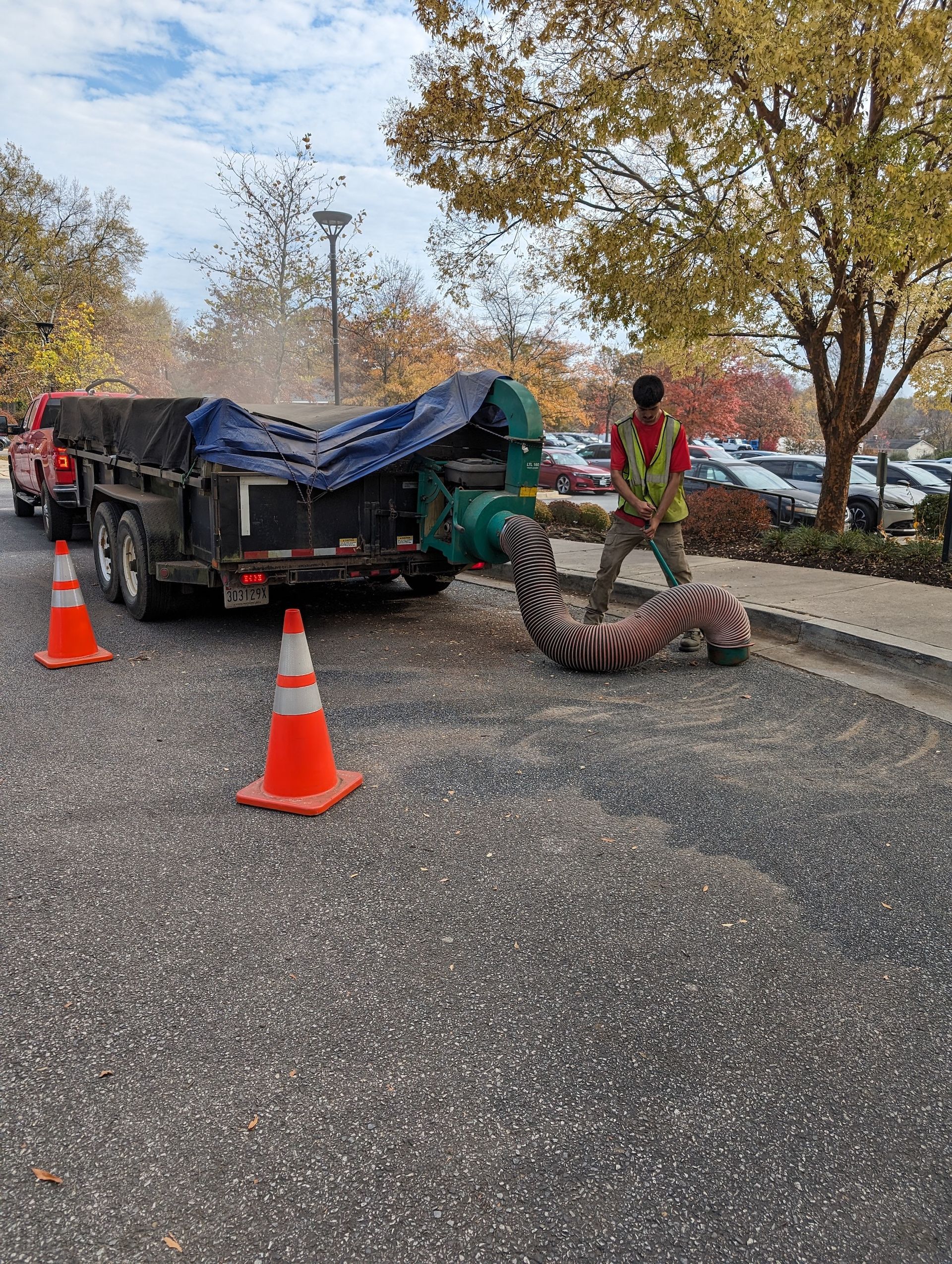 A man is standing next to a trailer in a parking lot.