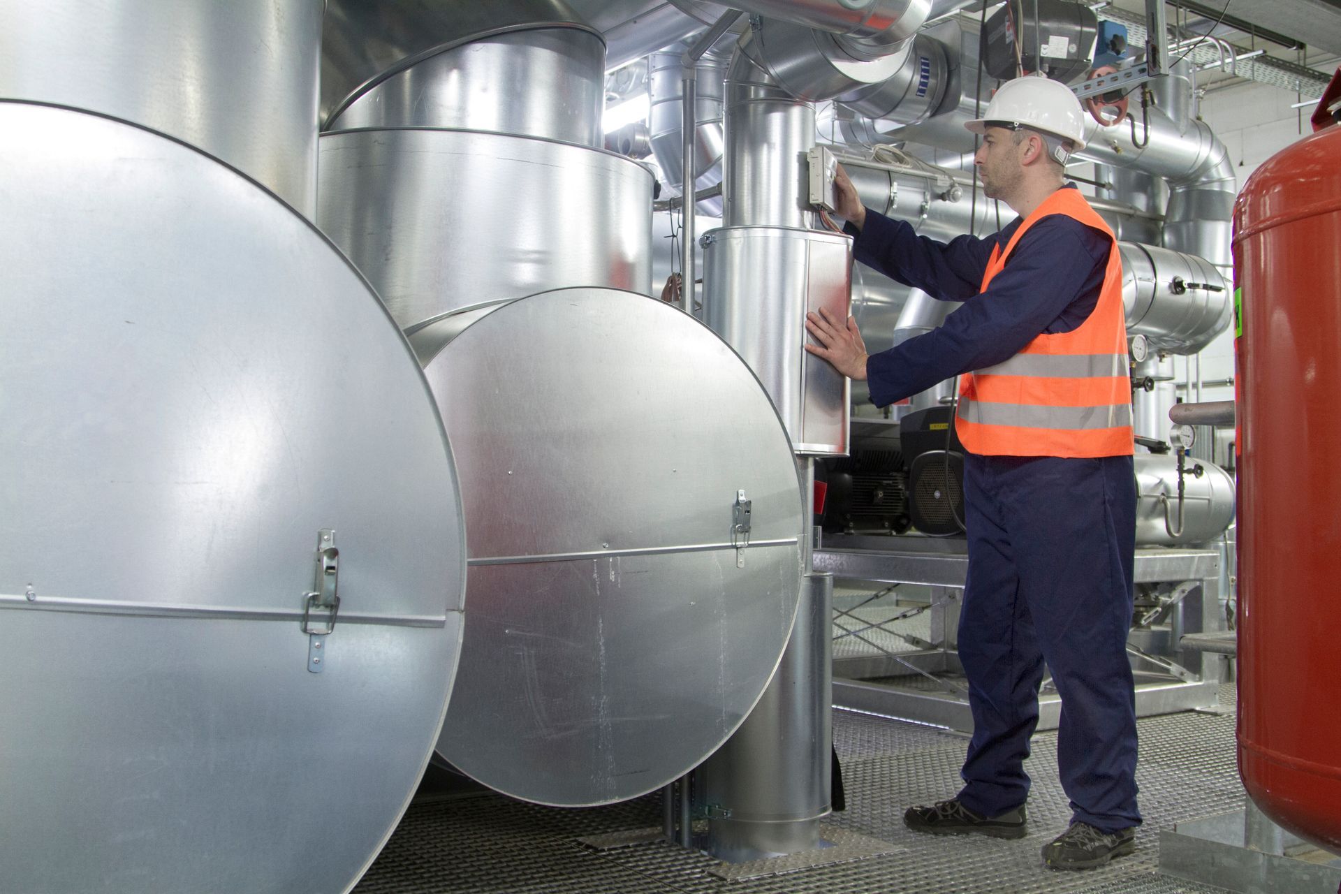 Technician inspecting industrial boiler system during maintenance service call