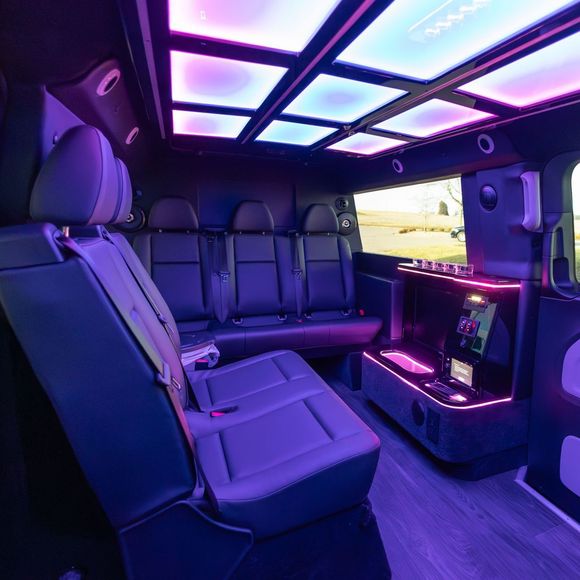 The inside of a van with purple lights on the ceiling.