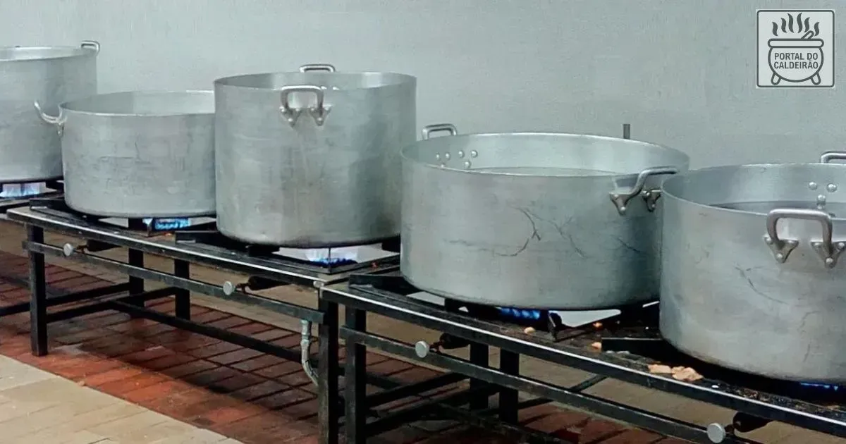 Imagem de panelas comuns em aluminio padrão hotel de 20 a 70 litros sobre um fogão a gás baixo industrial.