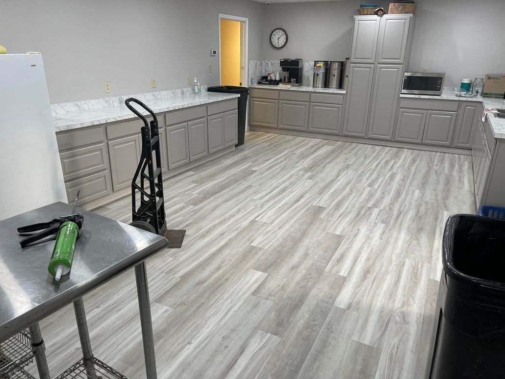 A large kitchen with a stainless steel table and a cart.