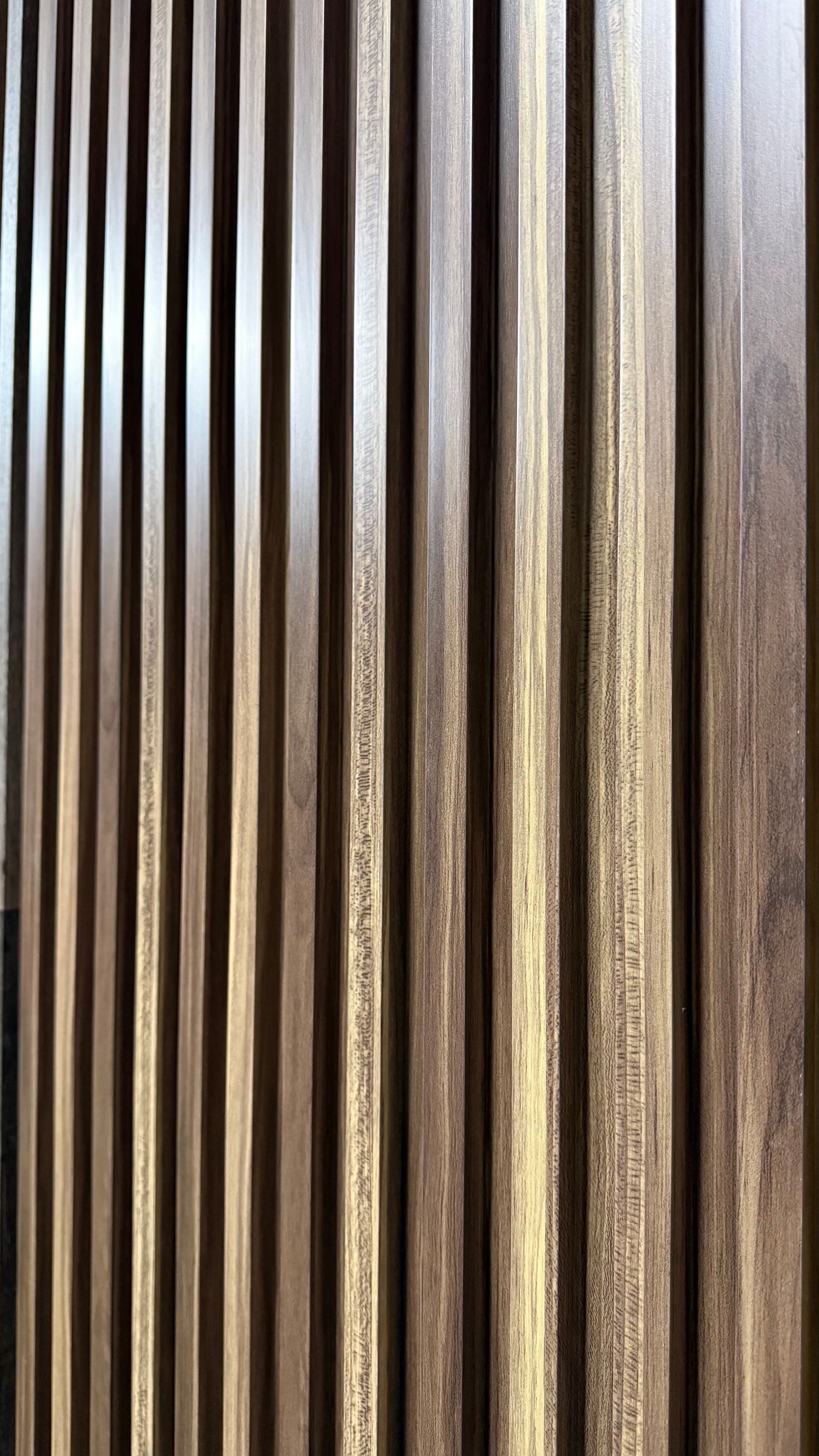 Listones verticales de madera oscura sobre un fondo de madera envejecida.