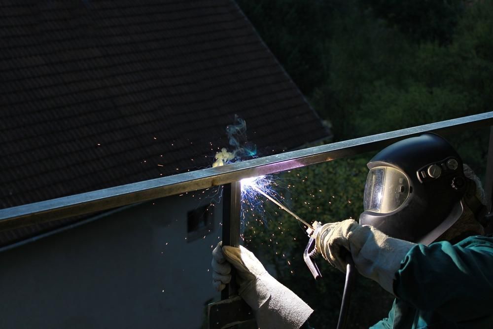 Man Wearing A Helmet Welds A Metal Fence — Hanby Welding & Engineering In Portsmith, QLD