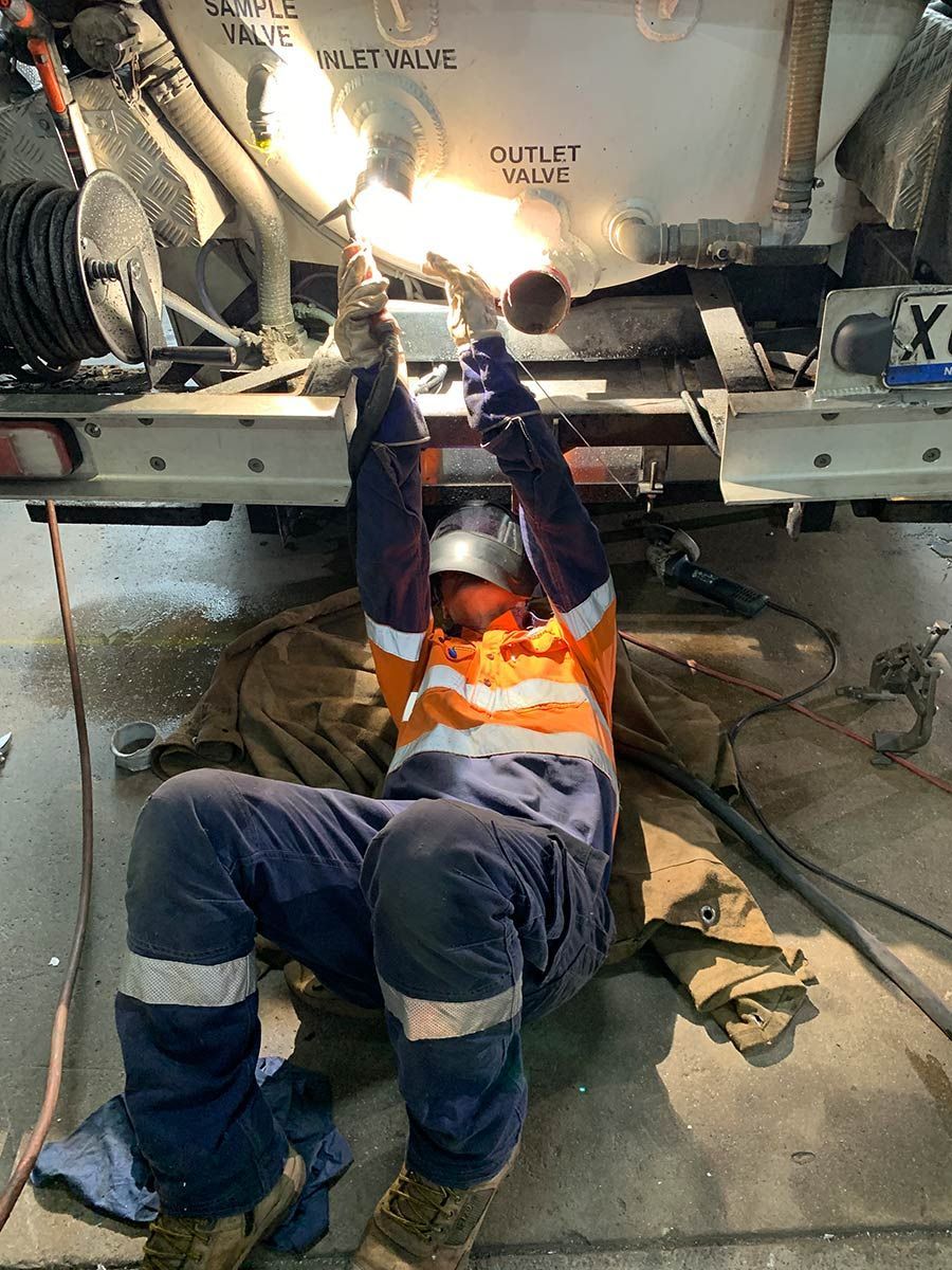 A Man Wearing A Welding Mask Is Working On A Piece Of Metal — Hanby Welding & Engineering In Portsmith, QLD