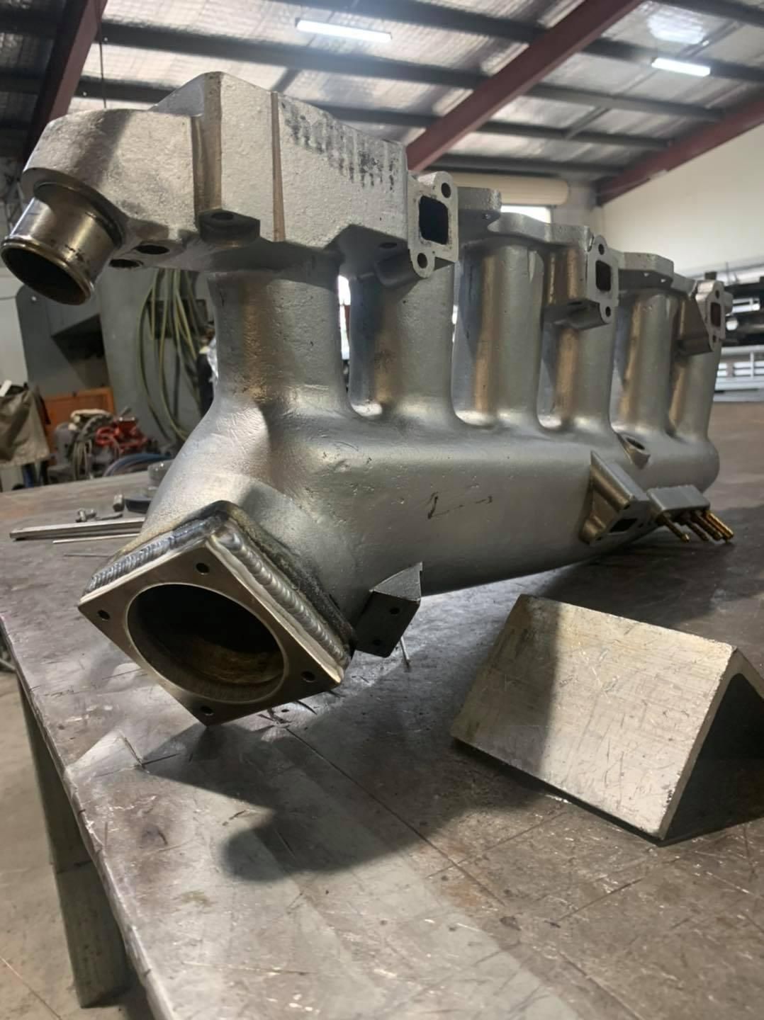 A Stainless Steel Pipe Is Sitting On Top Of A Metal Table — Hanby Welding & Engineering In Portsmith, QLD