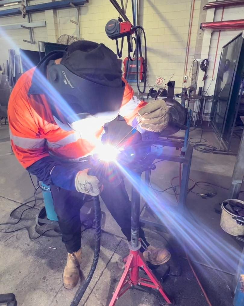 A Man Is Welding A Piece Of Metal In A Workshop — Hanby Welding & Engineering In Portsmith, QLD