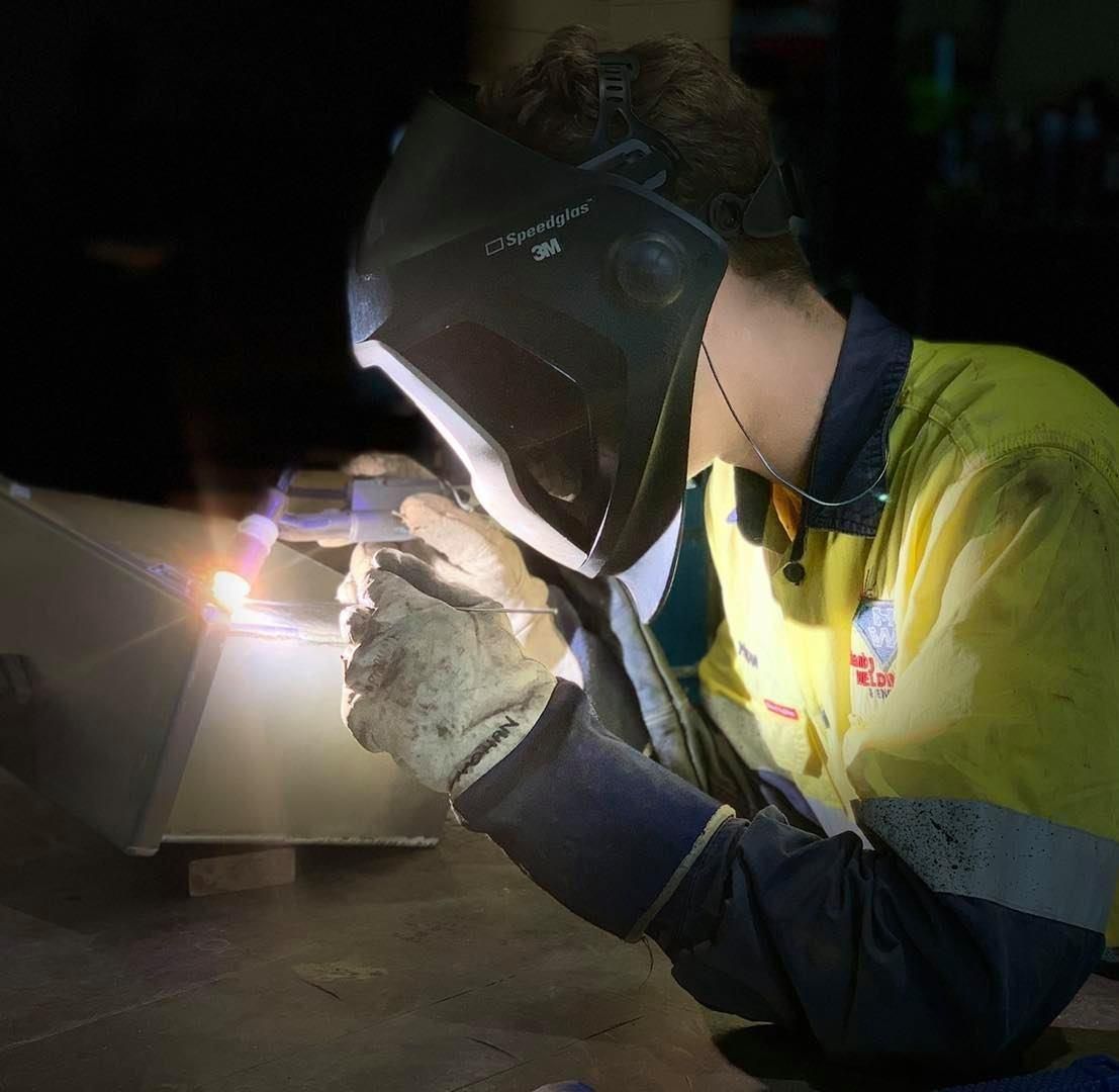A Man Wearing A Welding Mask Is Working On A Piece Of Metal — Hanby Welding & Engineering In Portsmith, QLD