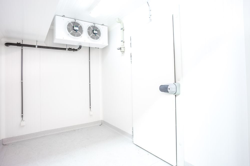 A Person Is Opening A Stainless Steel Refrigerator Door — Coolmech In Gympie, QLD
