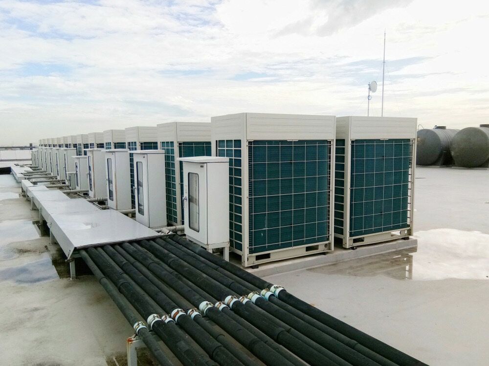 A Row Of Air Conditioners Are Sitting On Top Of A Roof — Coolmech In Gympie, QLD