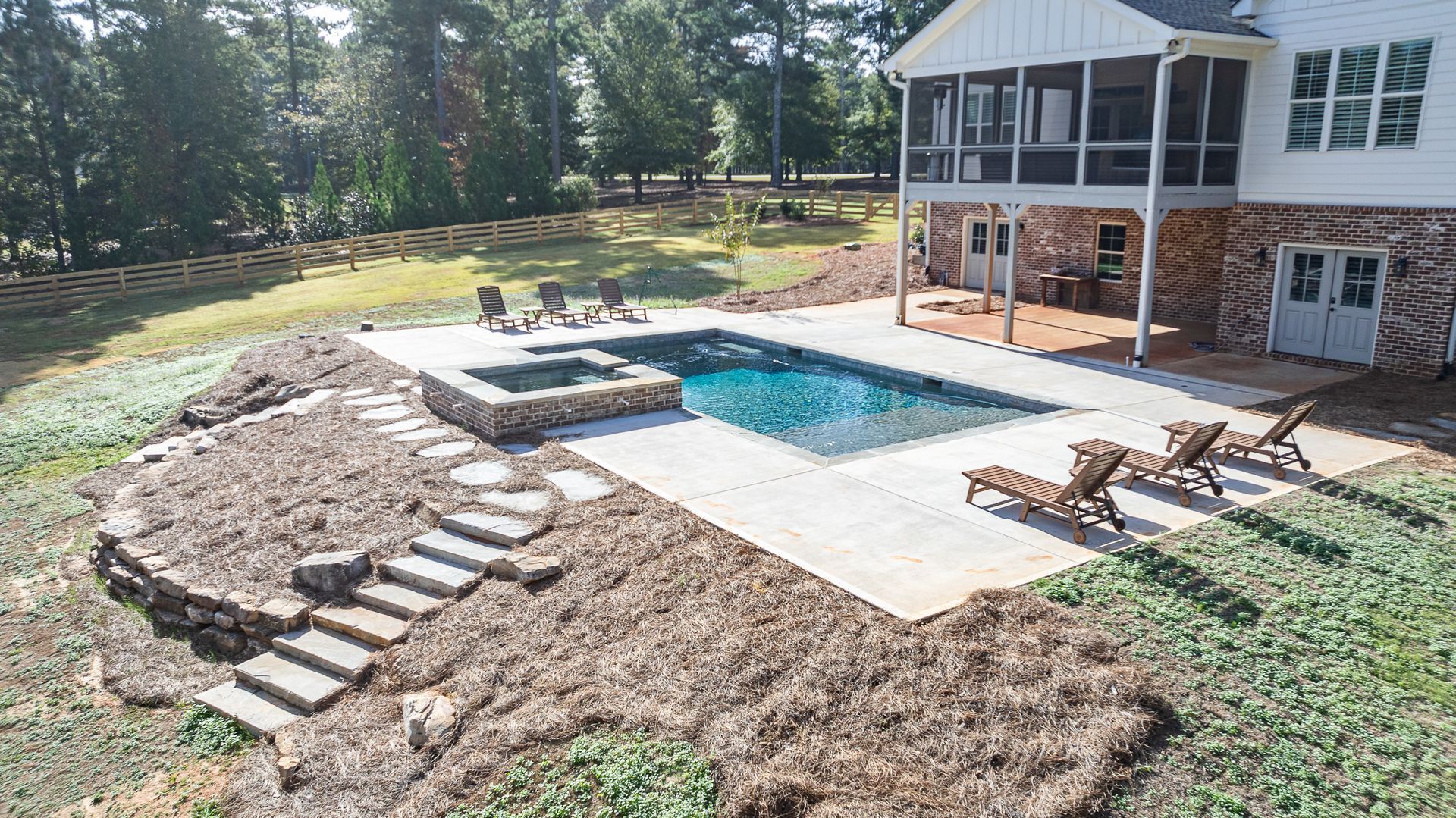 There is a large swimming pool in the backyard of a house.