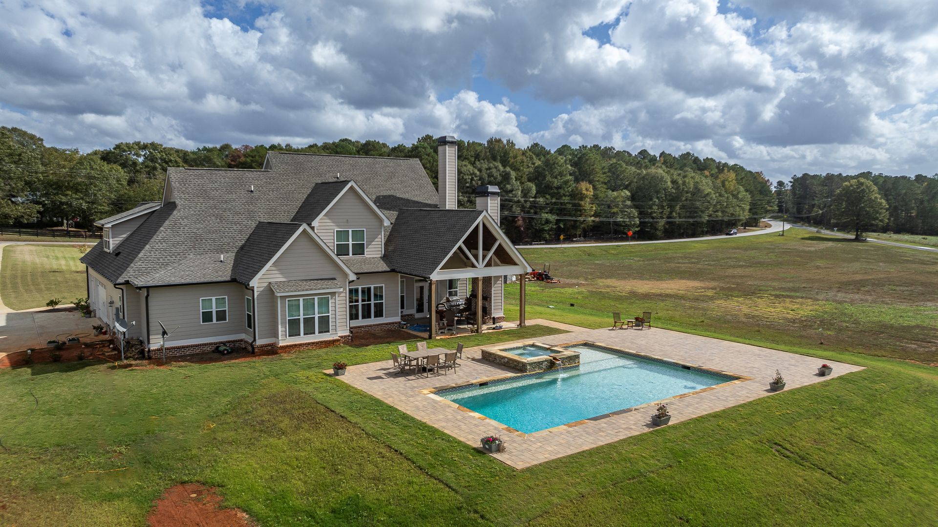 An aerial view of a house with a large swimming pool in the backyard.